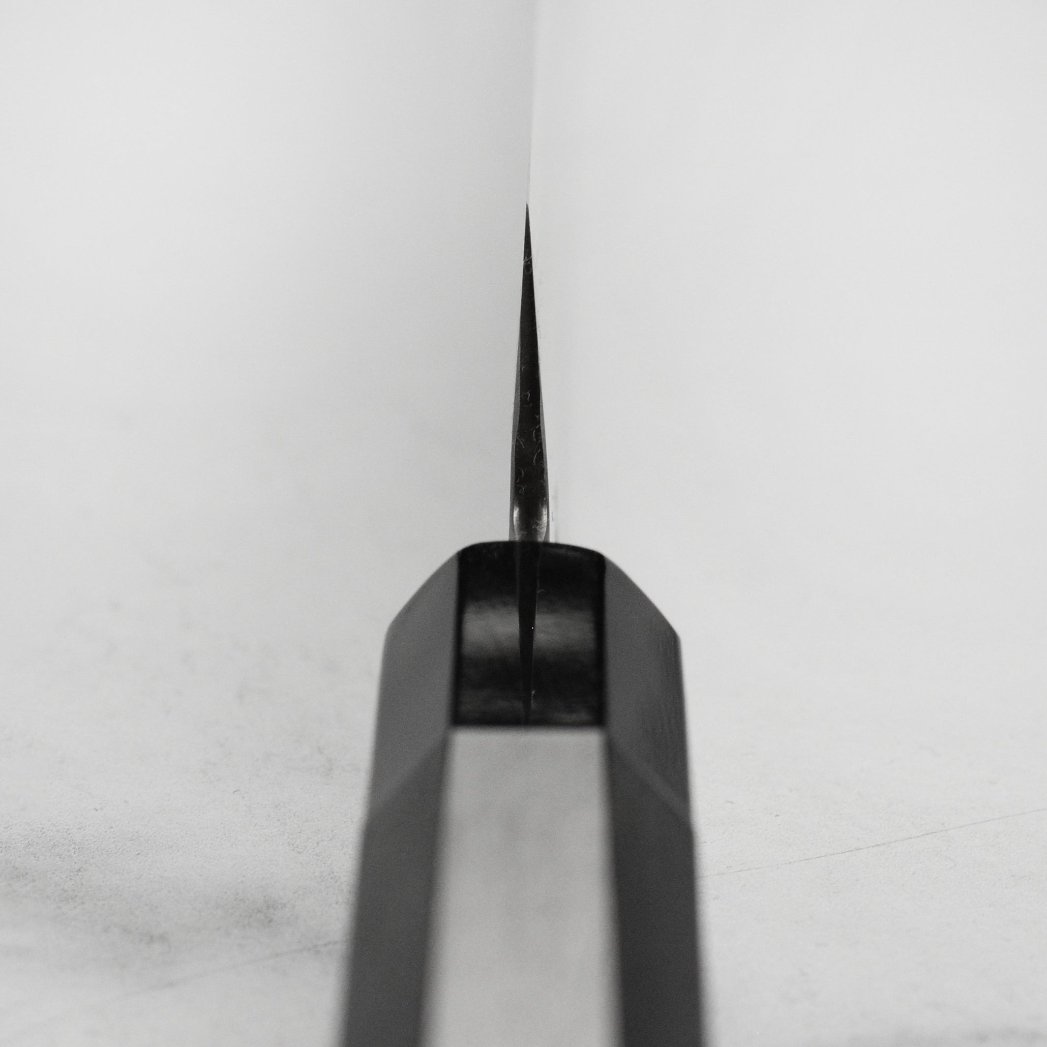 Sakai Ginsan Santoku knife in action, slicing fresh vegetables with precision.