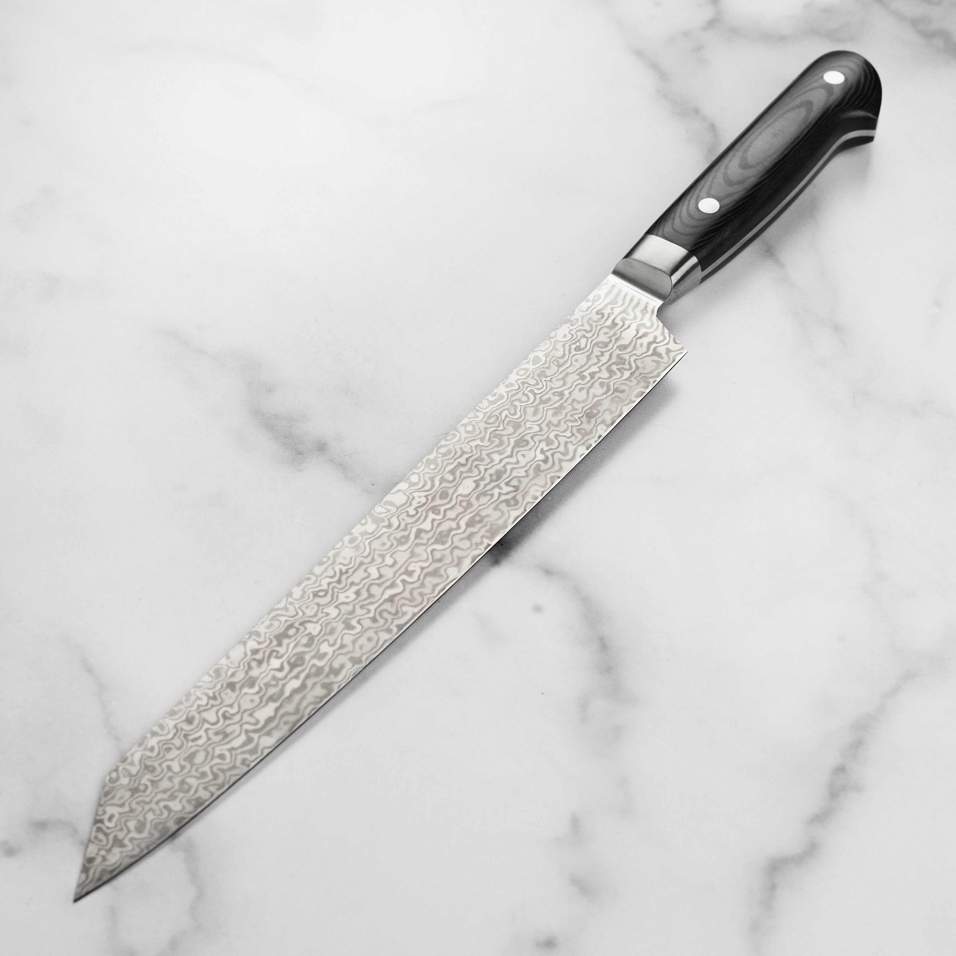Close-up of the VG10 coreless damascus steel sujihiki for precision slicing
