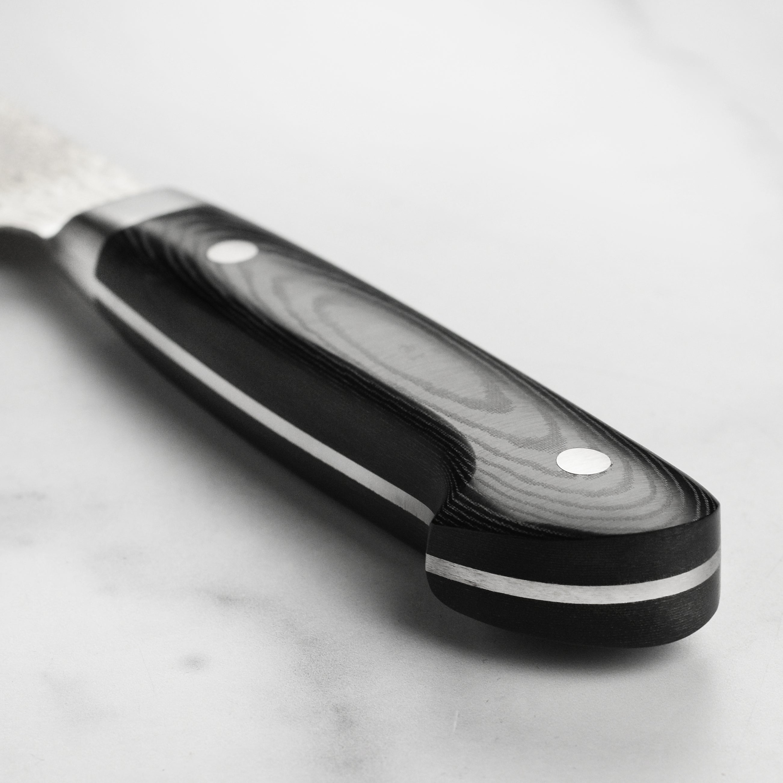 Sakai Takayuki 6.3" Bunka knife on a wooden cutting board, highlighting its elegant design.