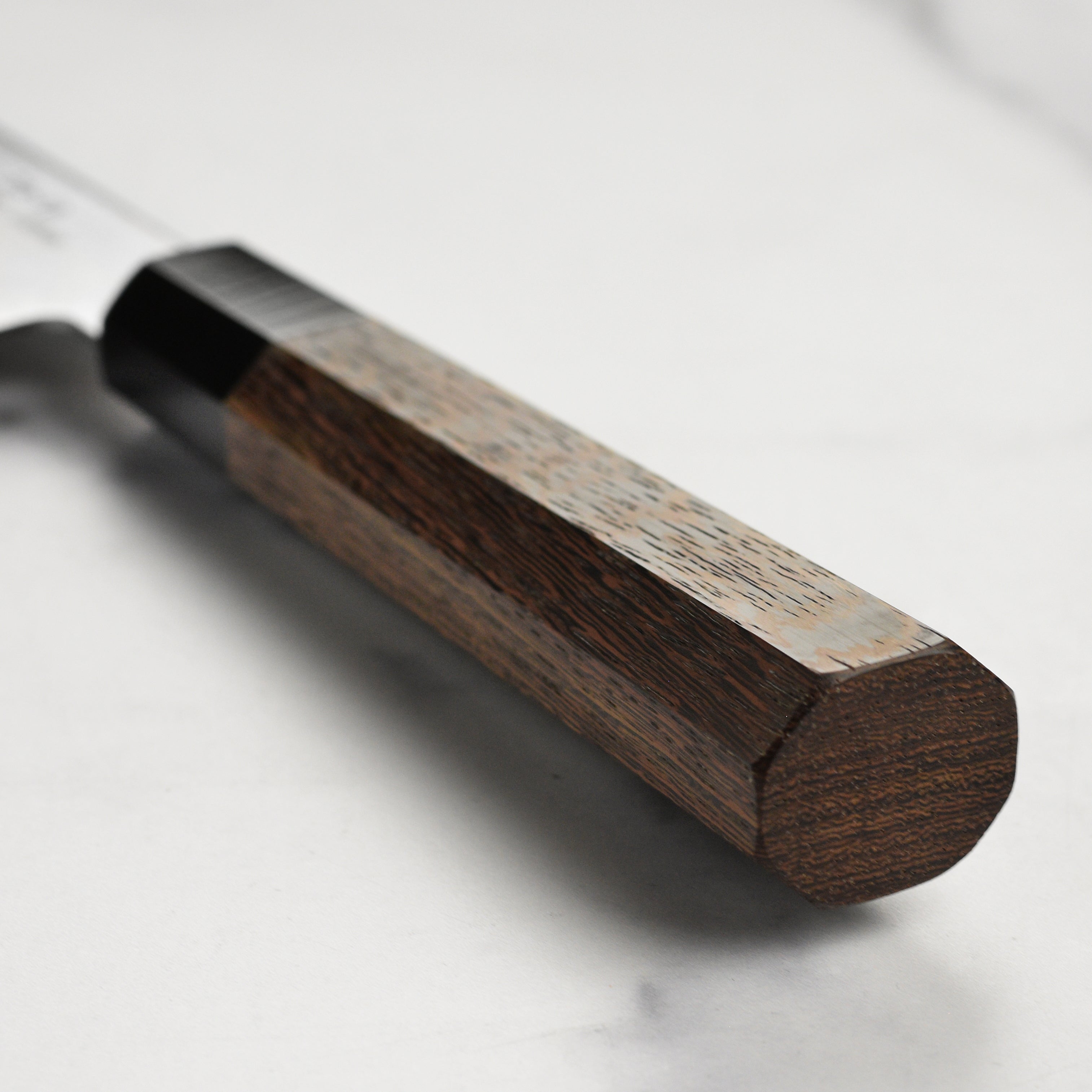 Close-up of the Wenge wood handle and buffalo horn ferrule of the Sakai Ginga knife.