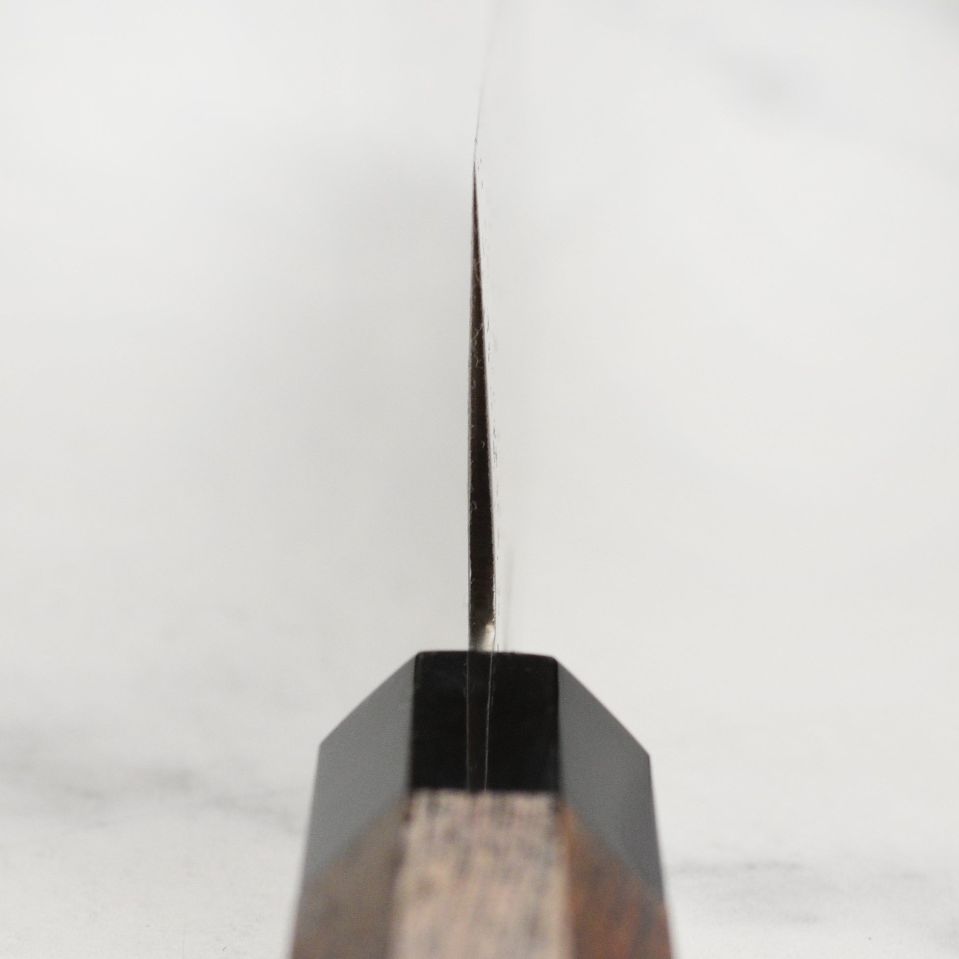 Close-up of the Wenge wood handle and buffalo horn ferrule of the Sakai Ginga knife.