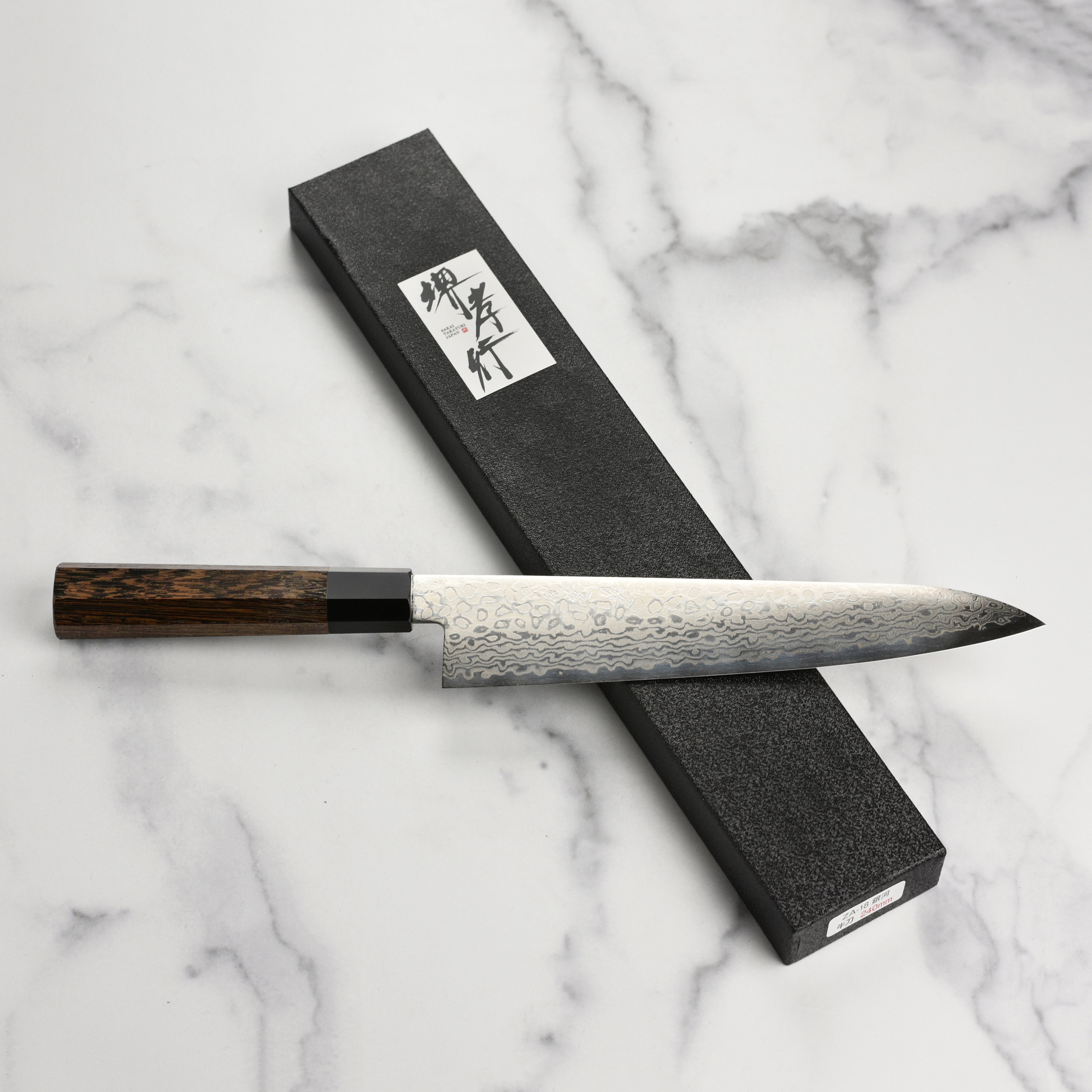 Sakai Ginga Damascus gyuto knife in action, slicing fresh vegetables.