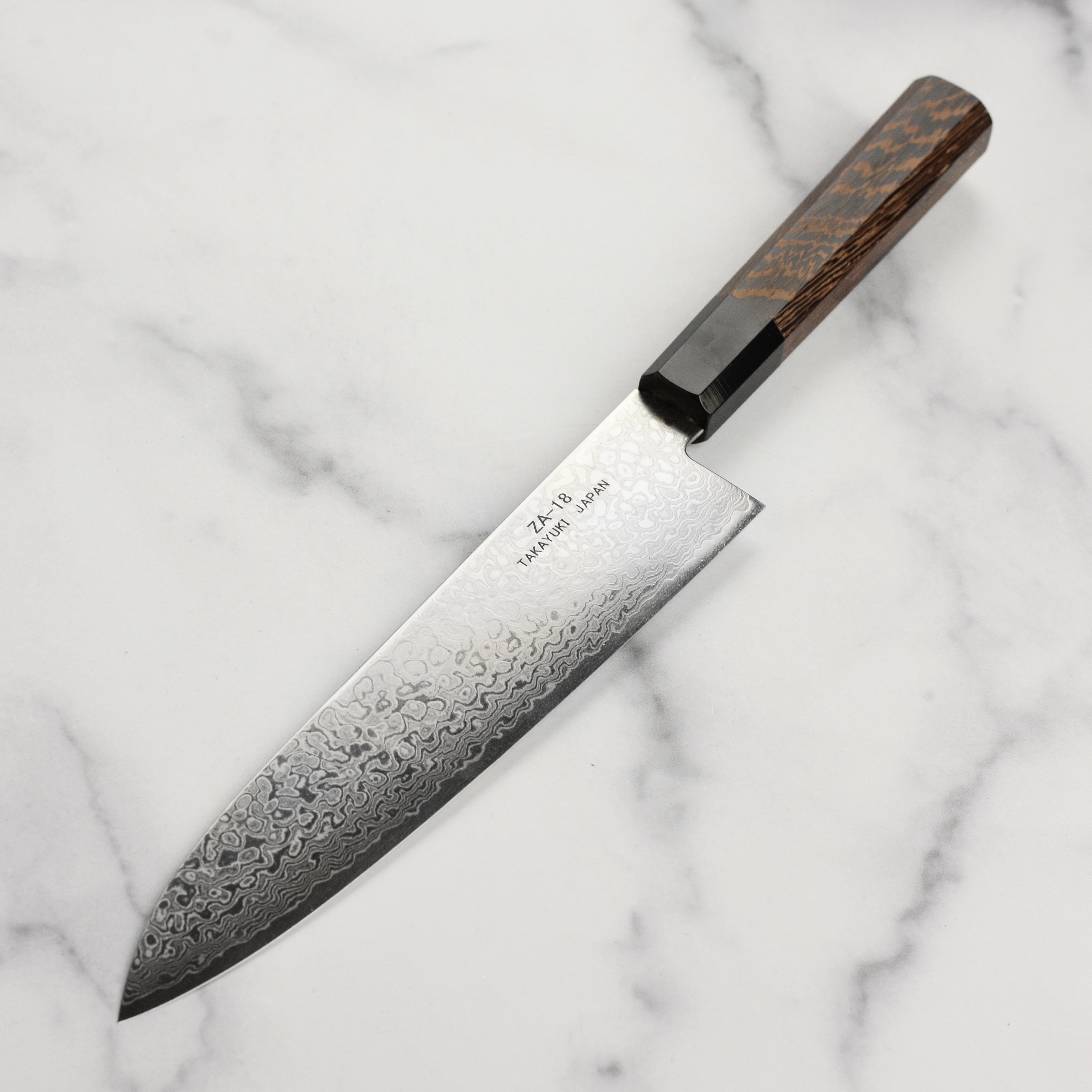 Display of the Ginga Damascus Chef Knife in action, slicing vegetables with precision.