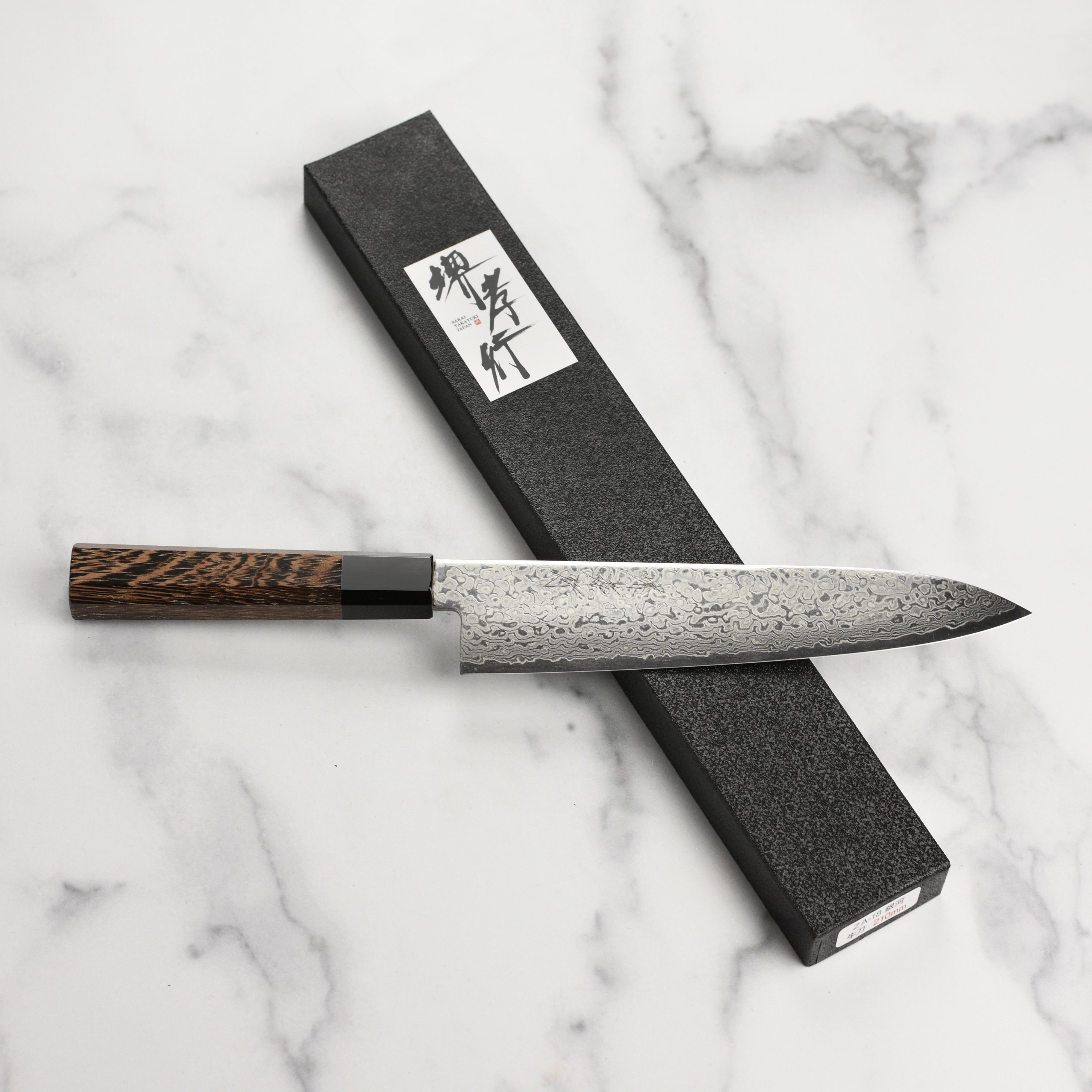 Close-up of the Wenge wood handle of the Ginga Gyuto knife, emphasizing its craftsmanship.