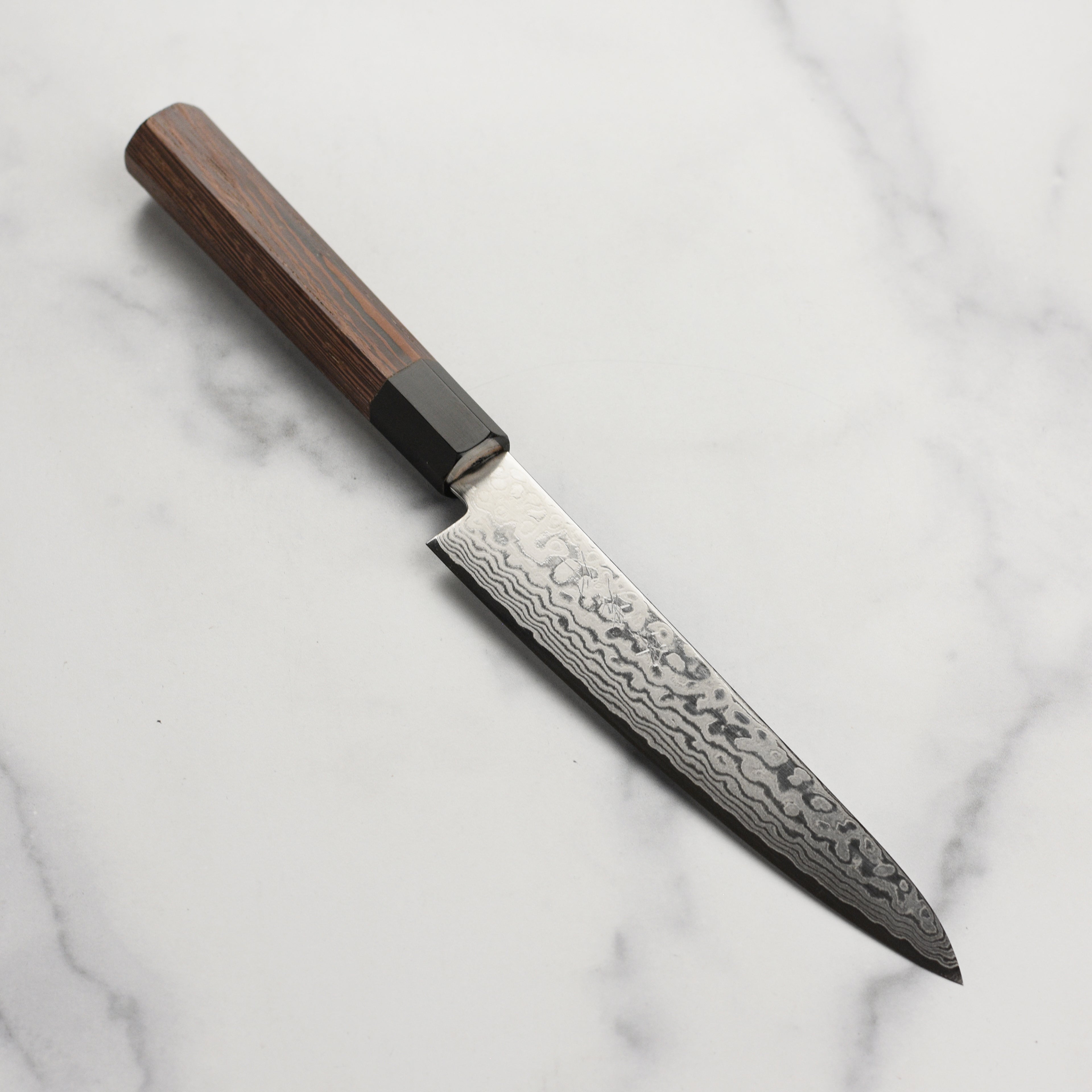 Close-up view of Takayuki Ginga ZA-18 petty knife showcasing its 69-layer Damascus blade and elegant handle.