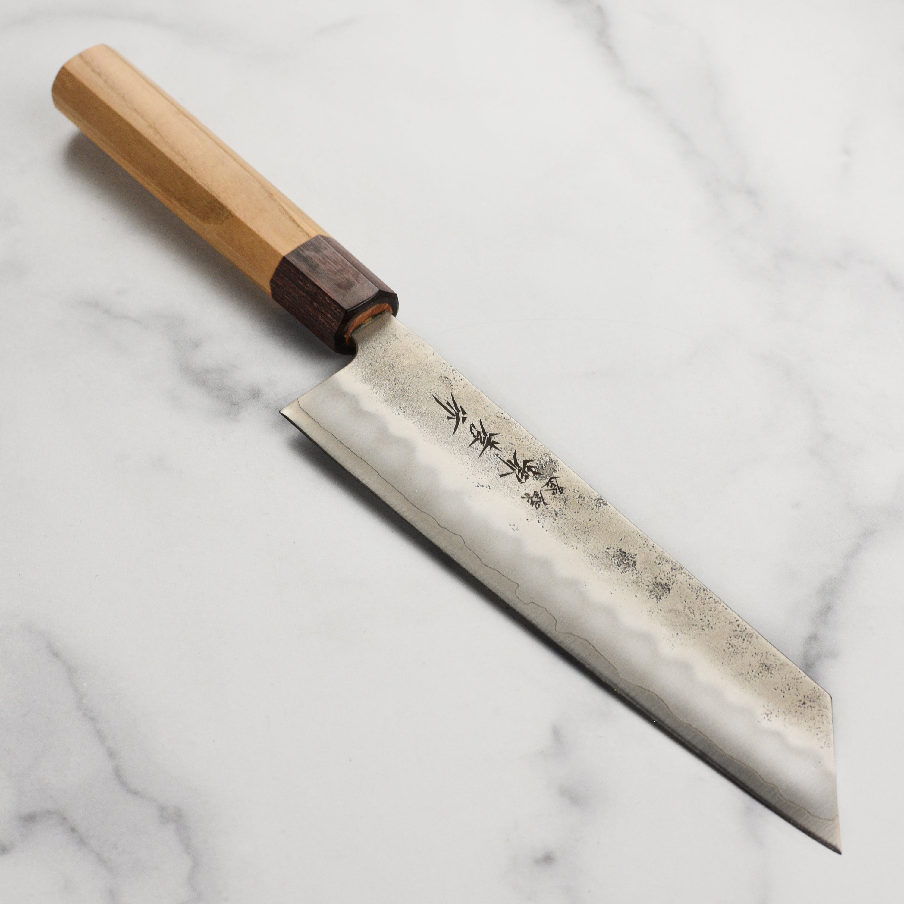 Sakai Ginsan Kiritsuke knife displayed from the side, highlighting its blade and handle design.