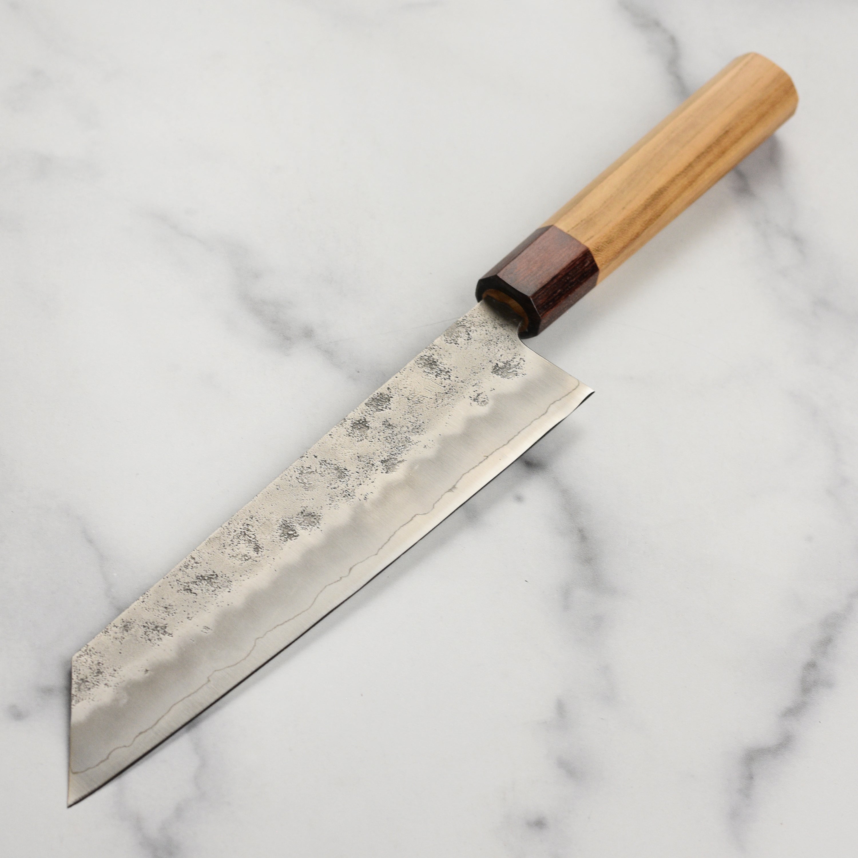 Close-up of the double bevel edge of the Sakai Ginsan Kiritsuke knife, emphasizing the nashiji finish.