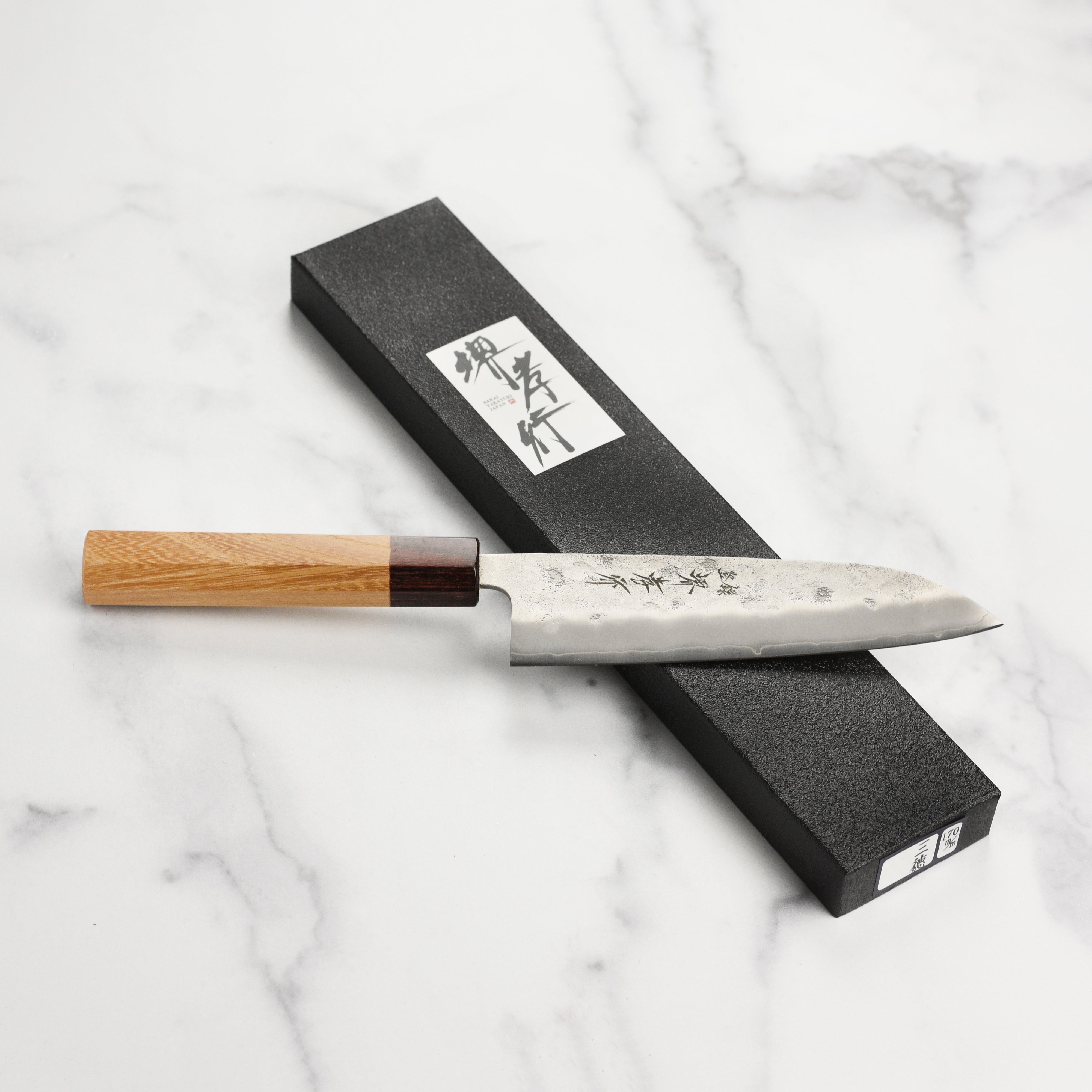 Close-up of the sharp edge and wooden handle of the Ginsan Santoku for easy slicing