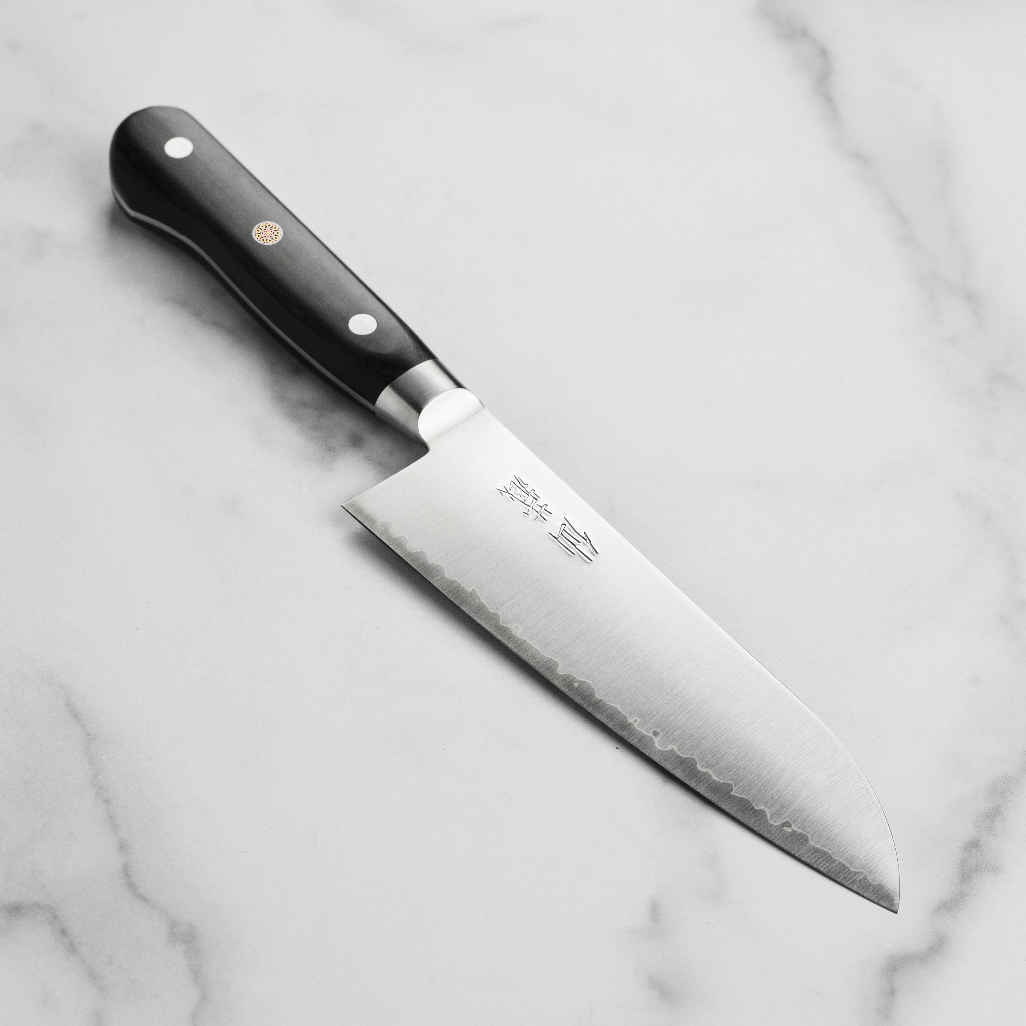 Detail of the Senzo Elite SG2 Santoku Knife showing the high-carbon blade and ergonomic handle.