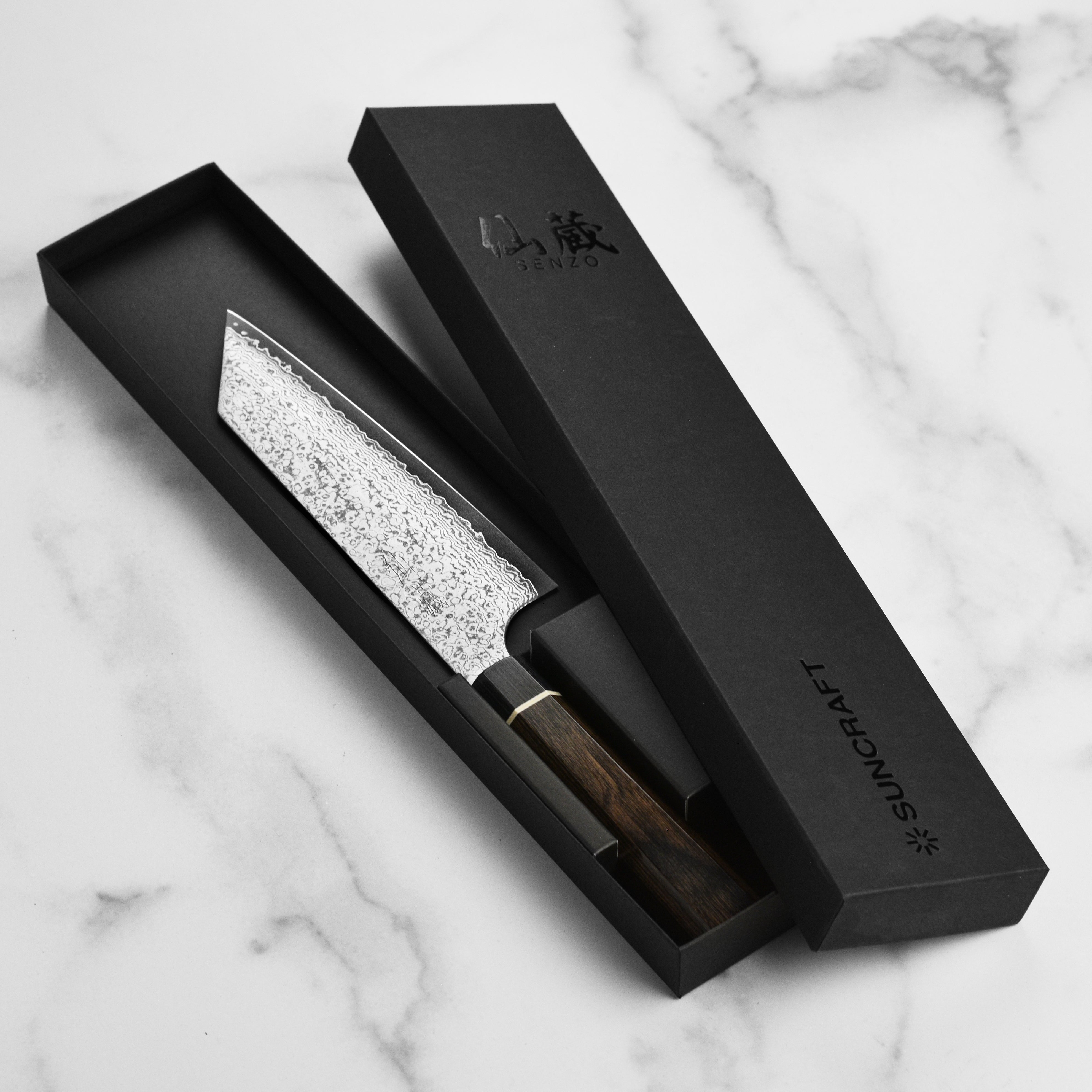 Suncraft Bunka knife cutting fresh vegetables on a wooden board