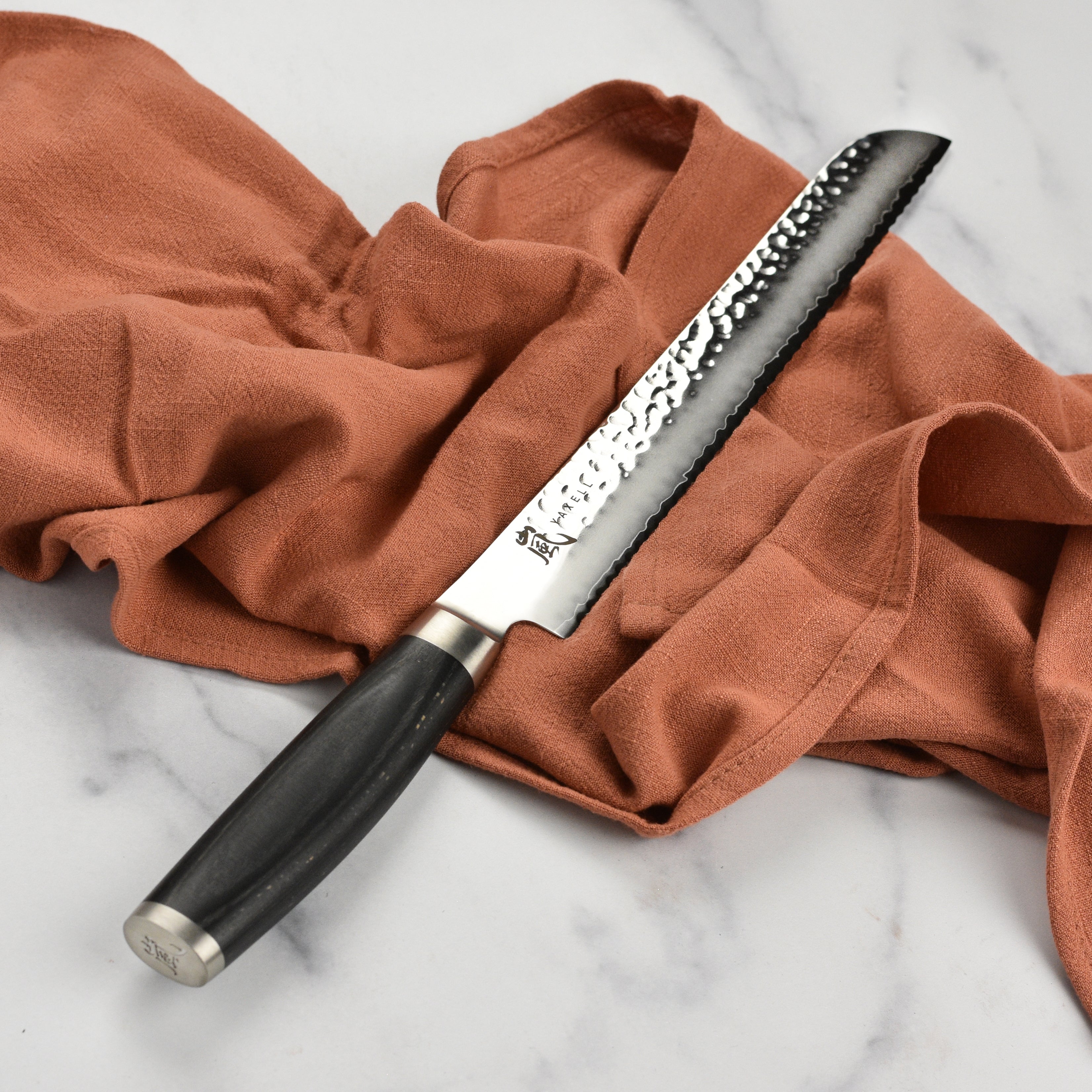 Yaxell Taishi bread knife in action, effortlessly slicing through crusty bread.