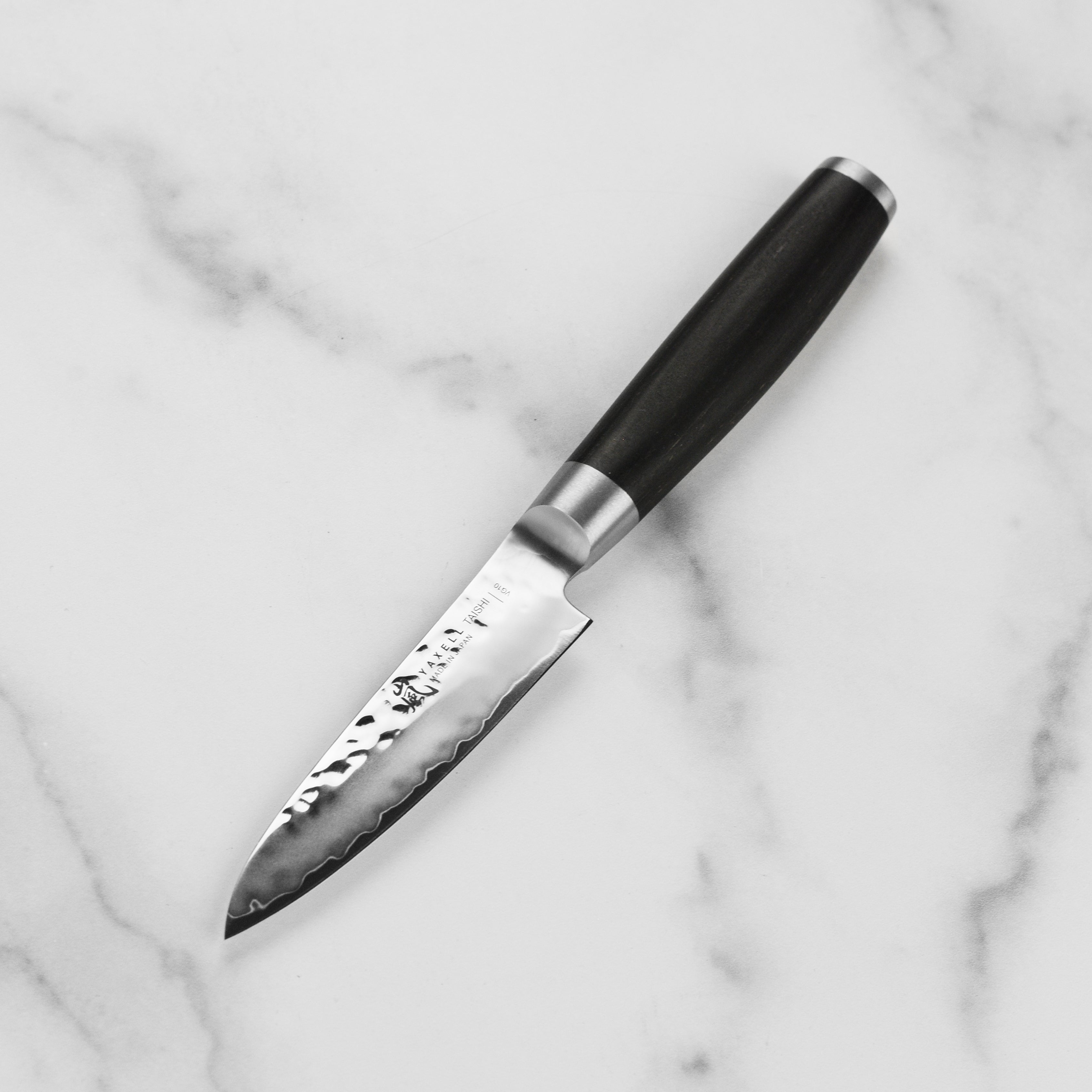 Elegant display of Yaxell Taishi paring knife with its black beech pakkawood handle and stainless steel bolster.