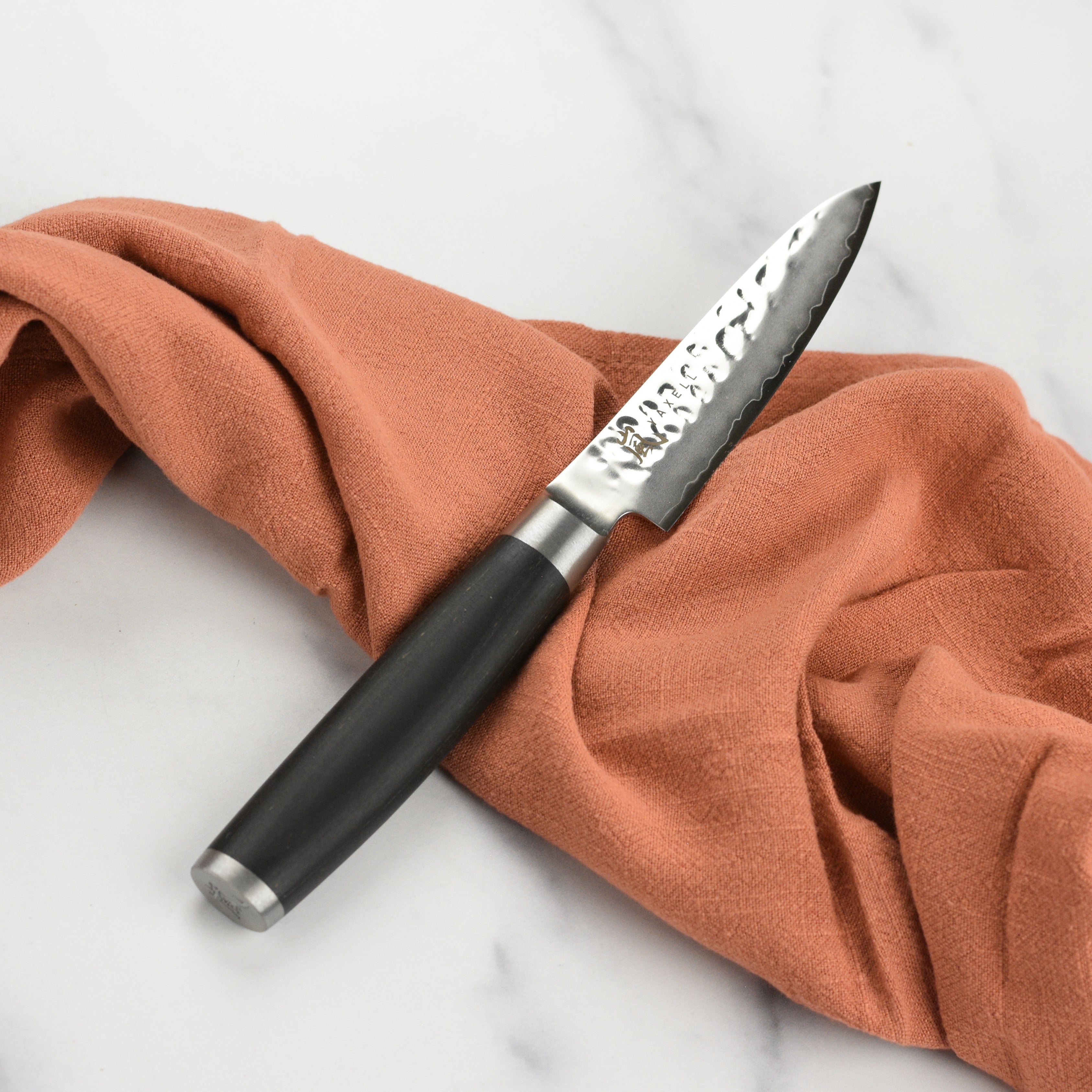 Yaxell Taishi paring knife in use, effortlessly slicing through fresh vegetables.