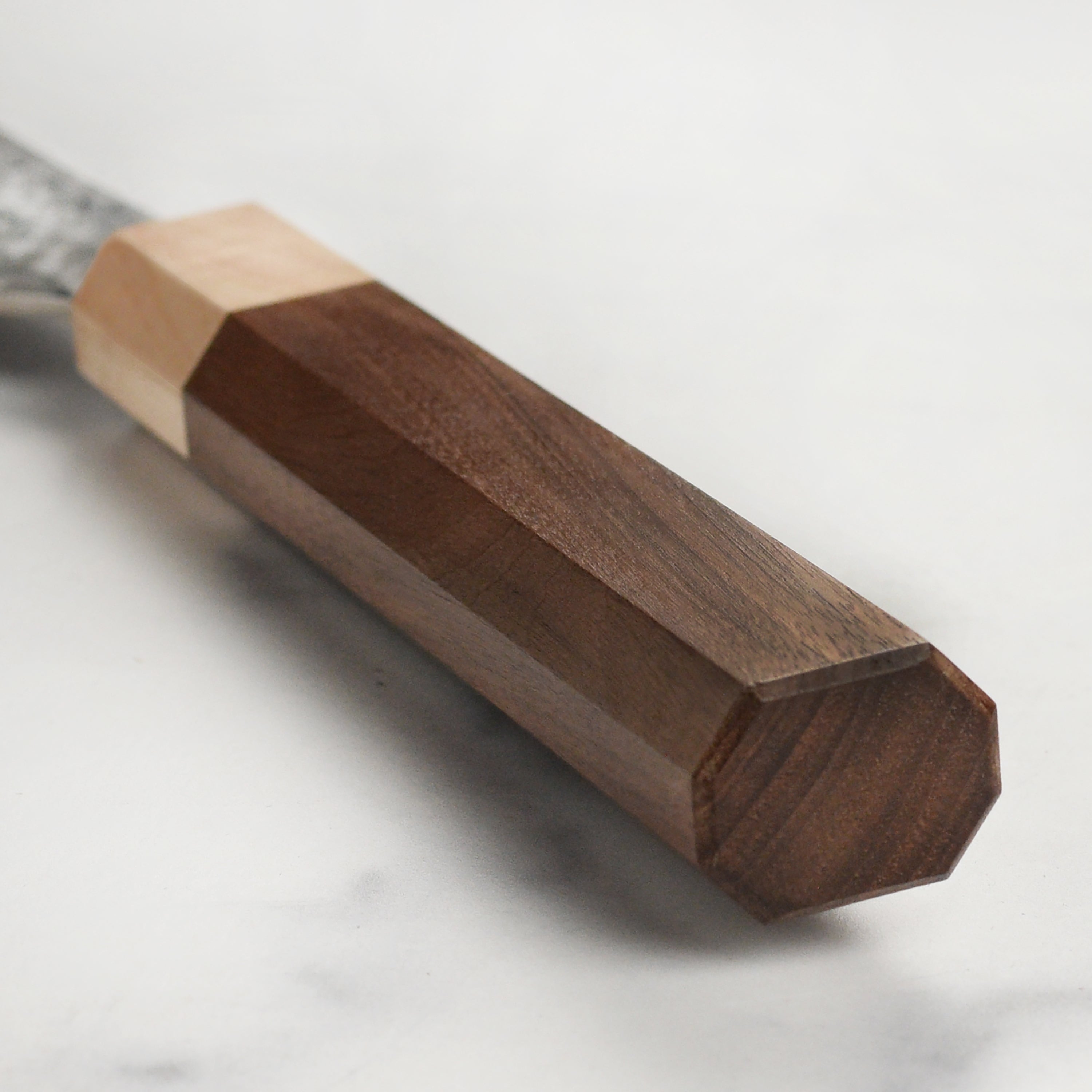 Close-up of the American walnut handle of the Kurosaki SG2 Gyuto knife.