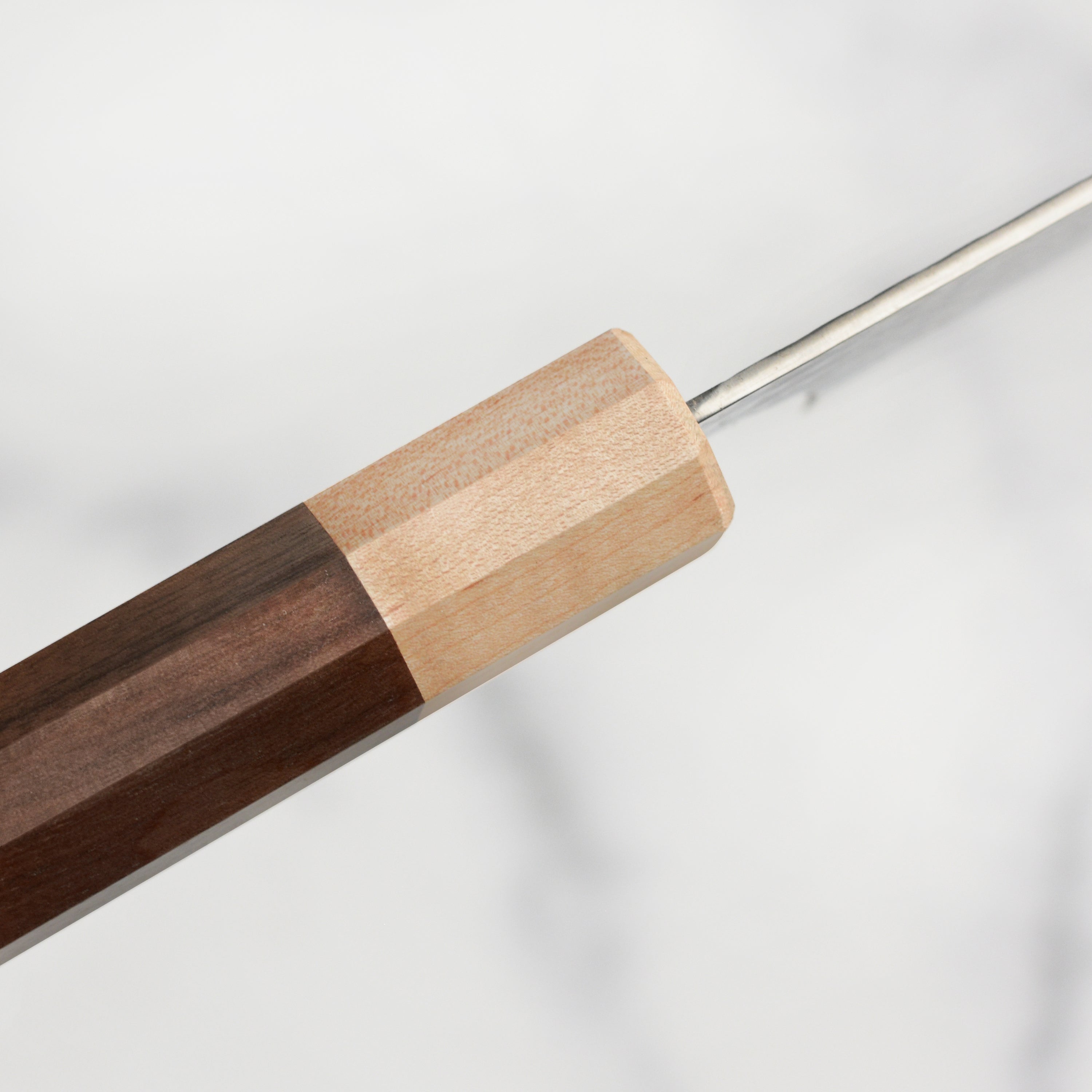 The Kurosaki Senko Ei 9.4" Gyuto knife on a wooden cutting board, showcasing its superior craftsmanship and ergonomic handle.