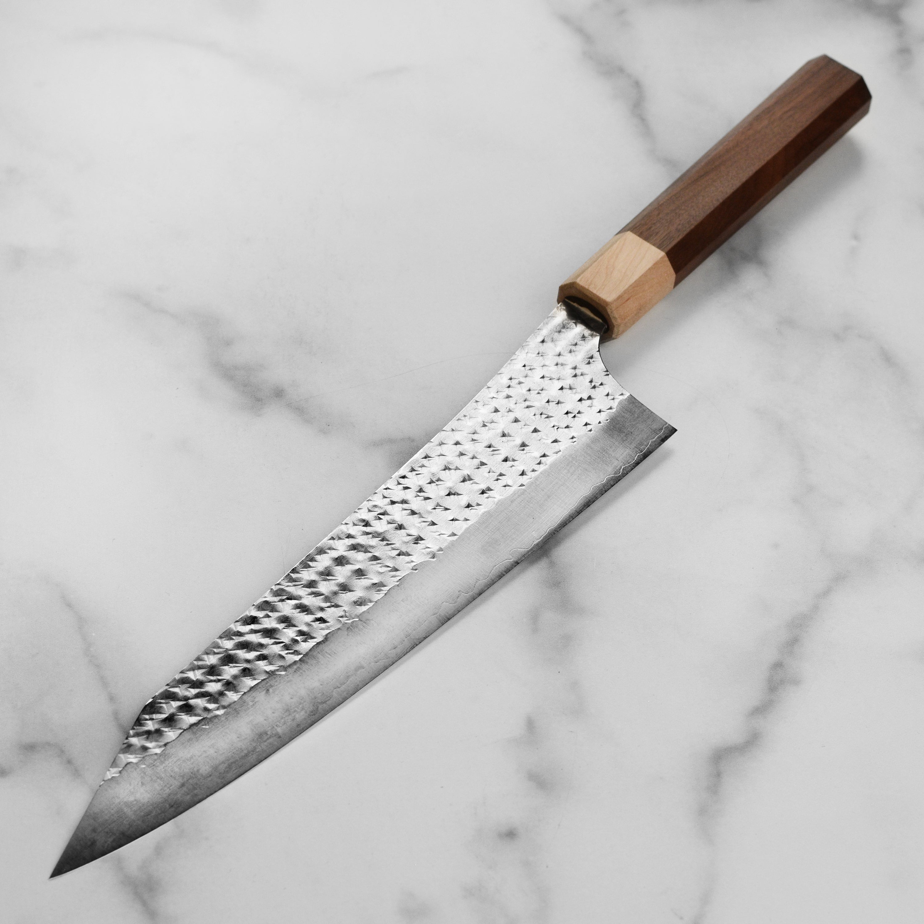 Side angle of the Kurosaki Senko Ei 9.4" Gyuto knife with a view of its American walnut octagonal handle and polished stainless steel blade.