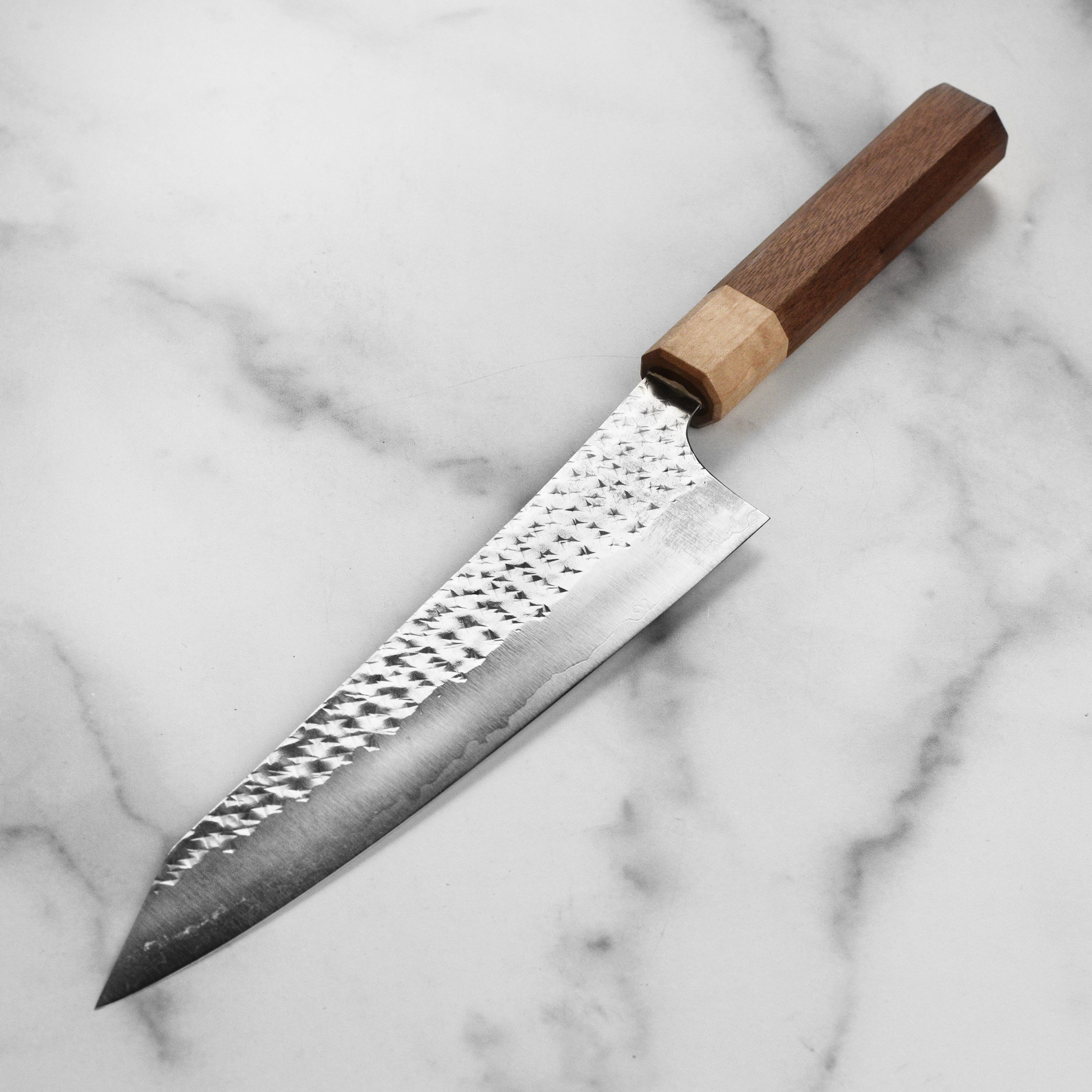 Close-up of the American walnut handle of the Kurosaki SG2 Gyuto knife.