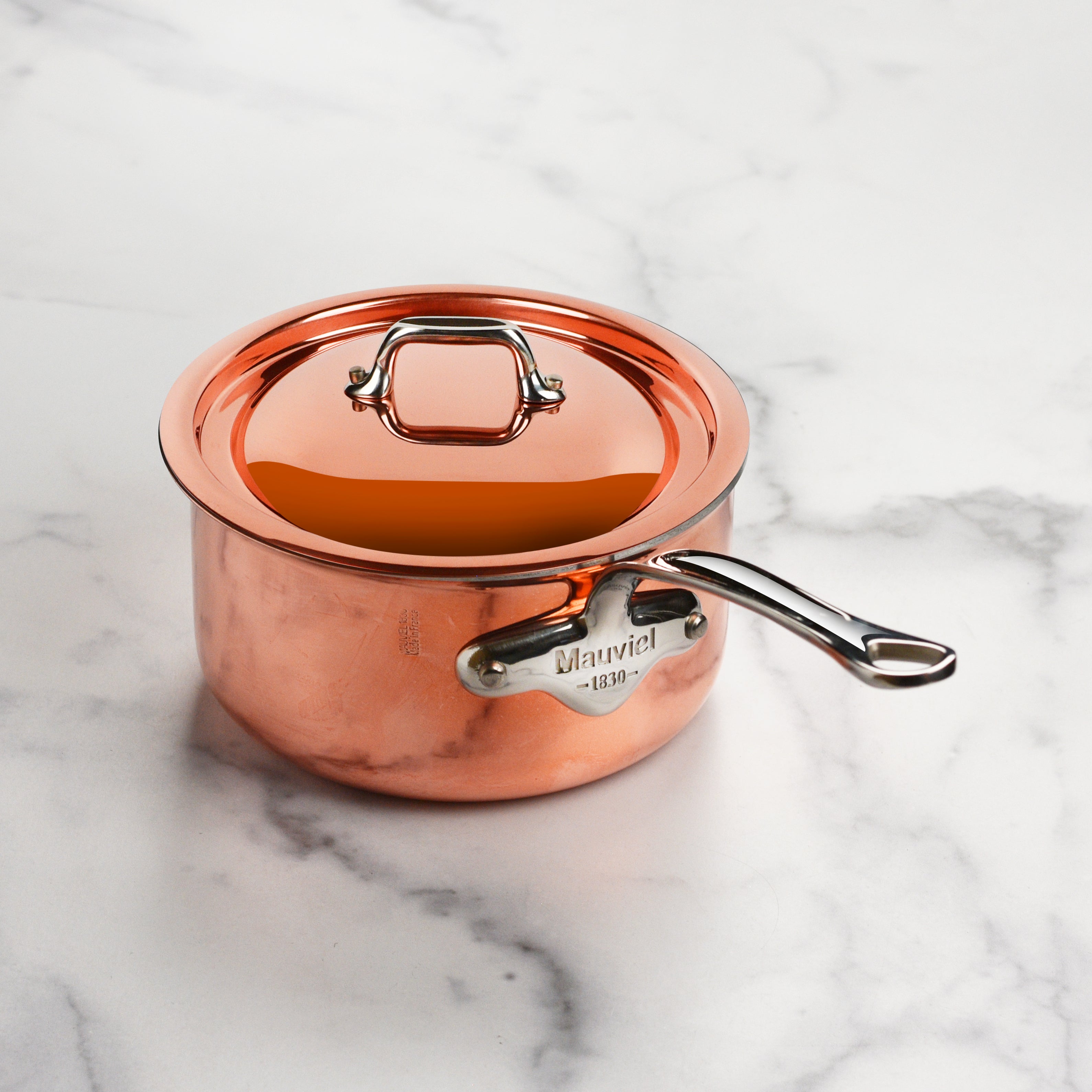 Side profile of Mauviel saucepan pouring sauce cleanly thanks to flared rim, demonstrating usability for professionals
