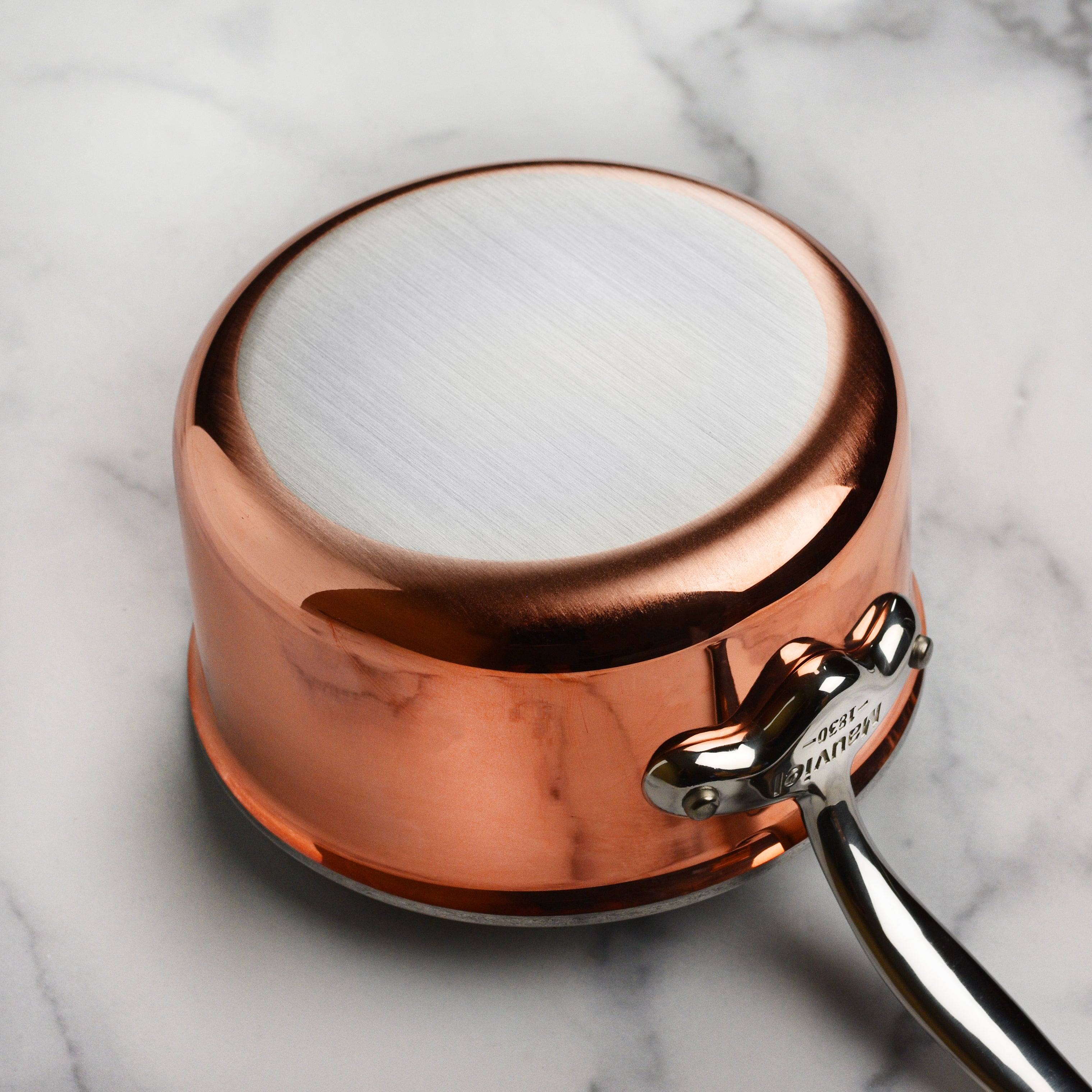 Side profile of Mauviel saucepan pouring sauce cleanly thanks to flared rim, demonstrating usability for professionals