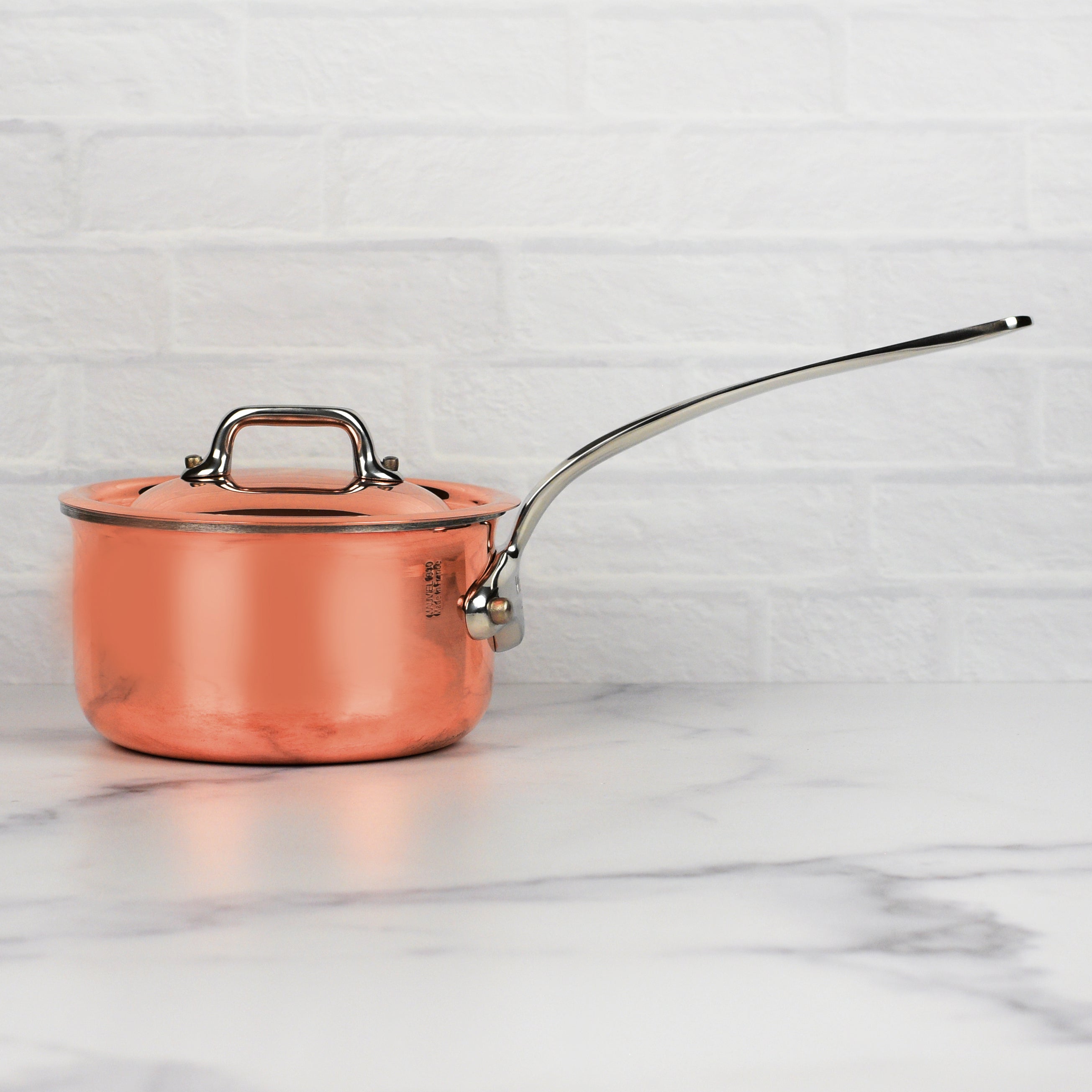Copper saucepan being used on an induction cooktop for precise heat control