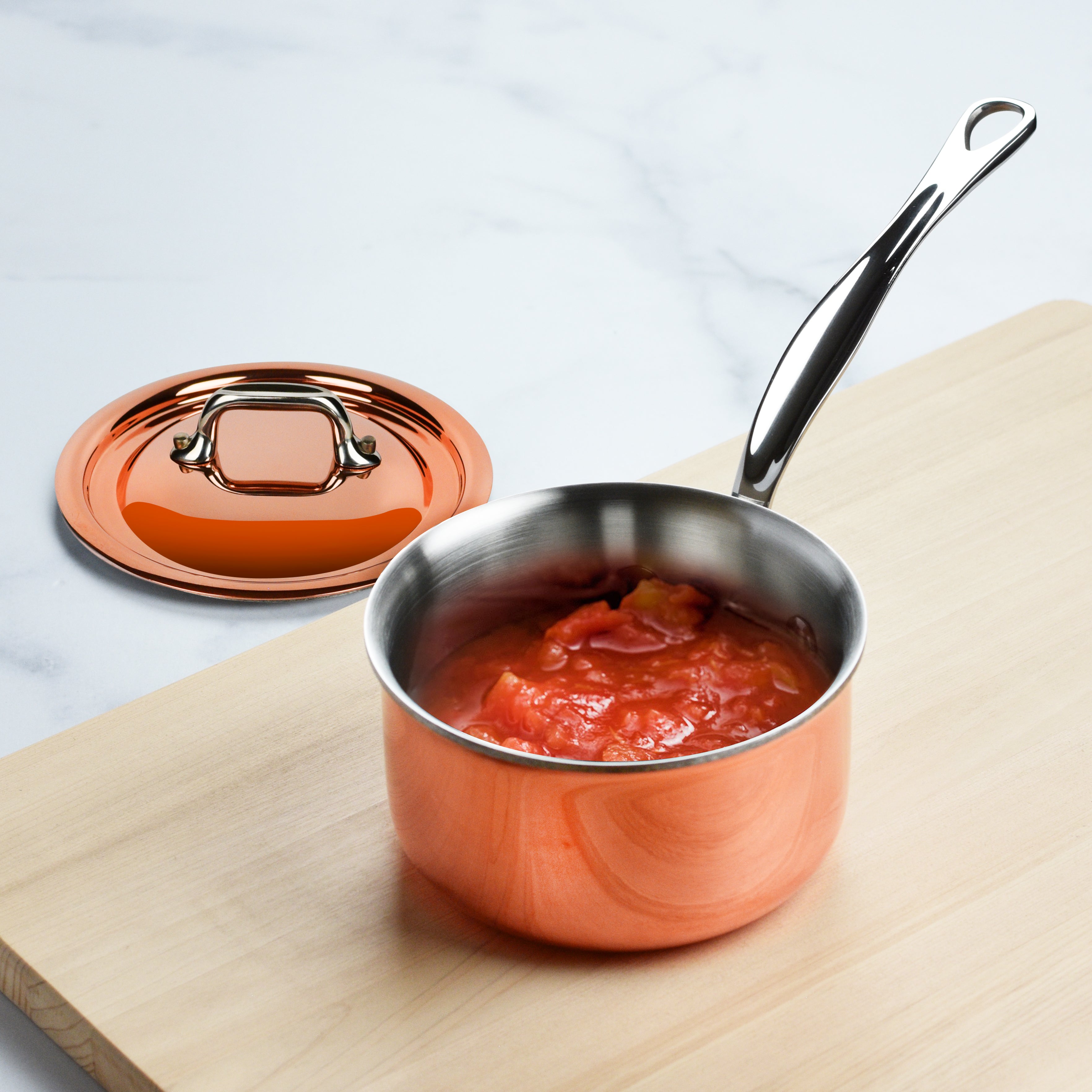 Copper saucepan being used on an induction cooktop for precise heat control