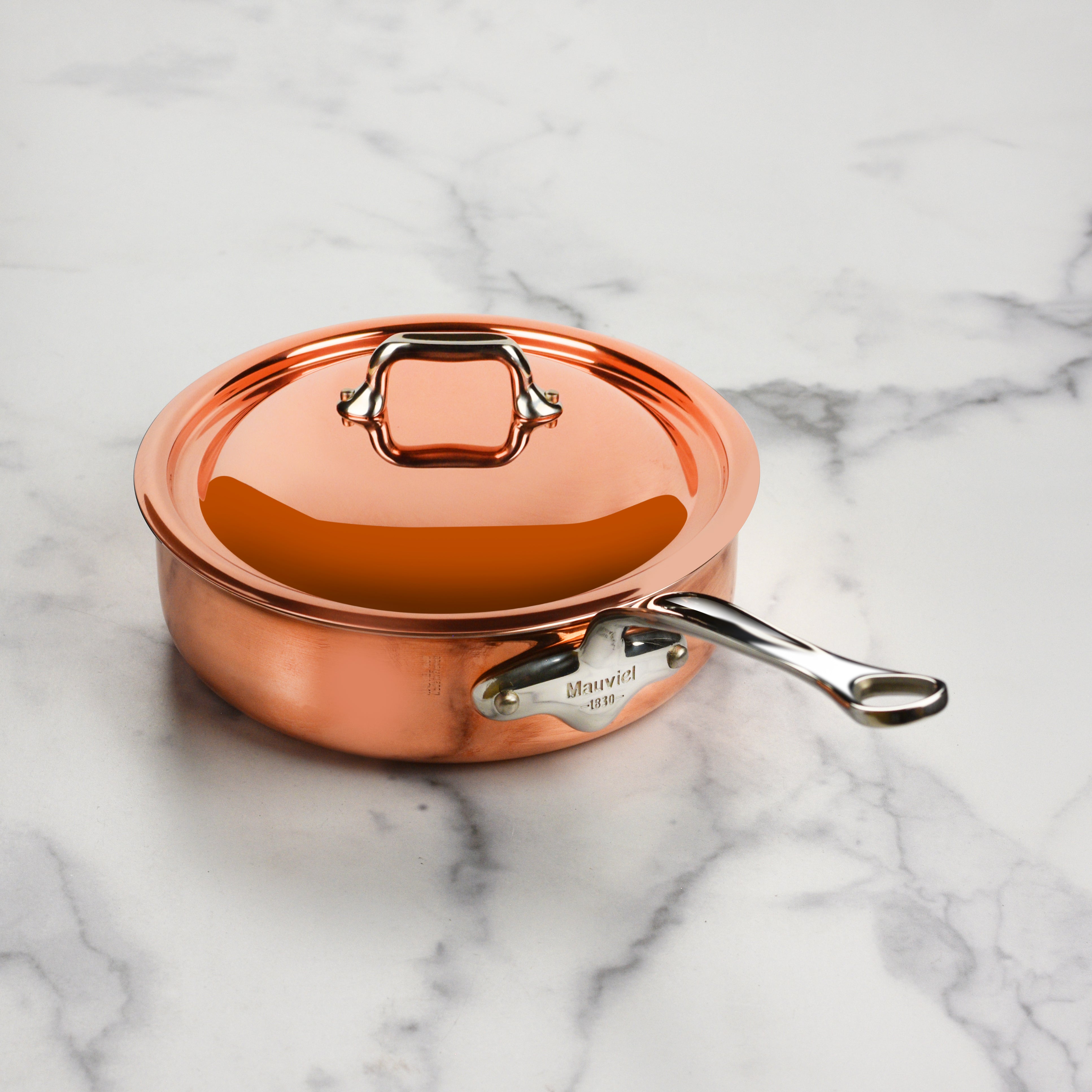 Mauviel M6S saute pan on an induction cooktop, showcasing its compatibility with various heat sources.