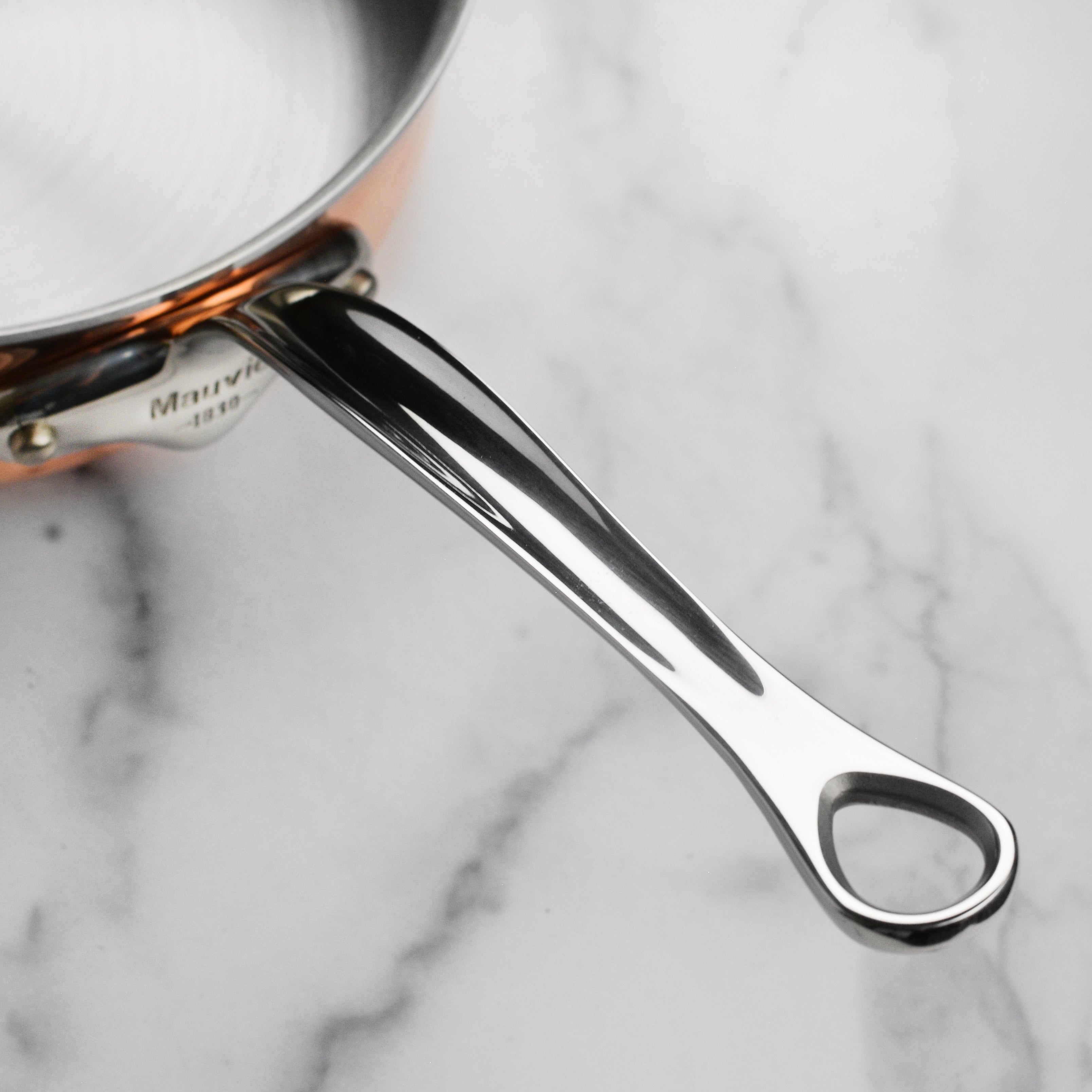 Mauviel M6S copper saute pan with lid, highlighting its elegant finish and sturdy handle.