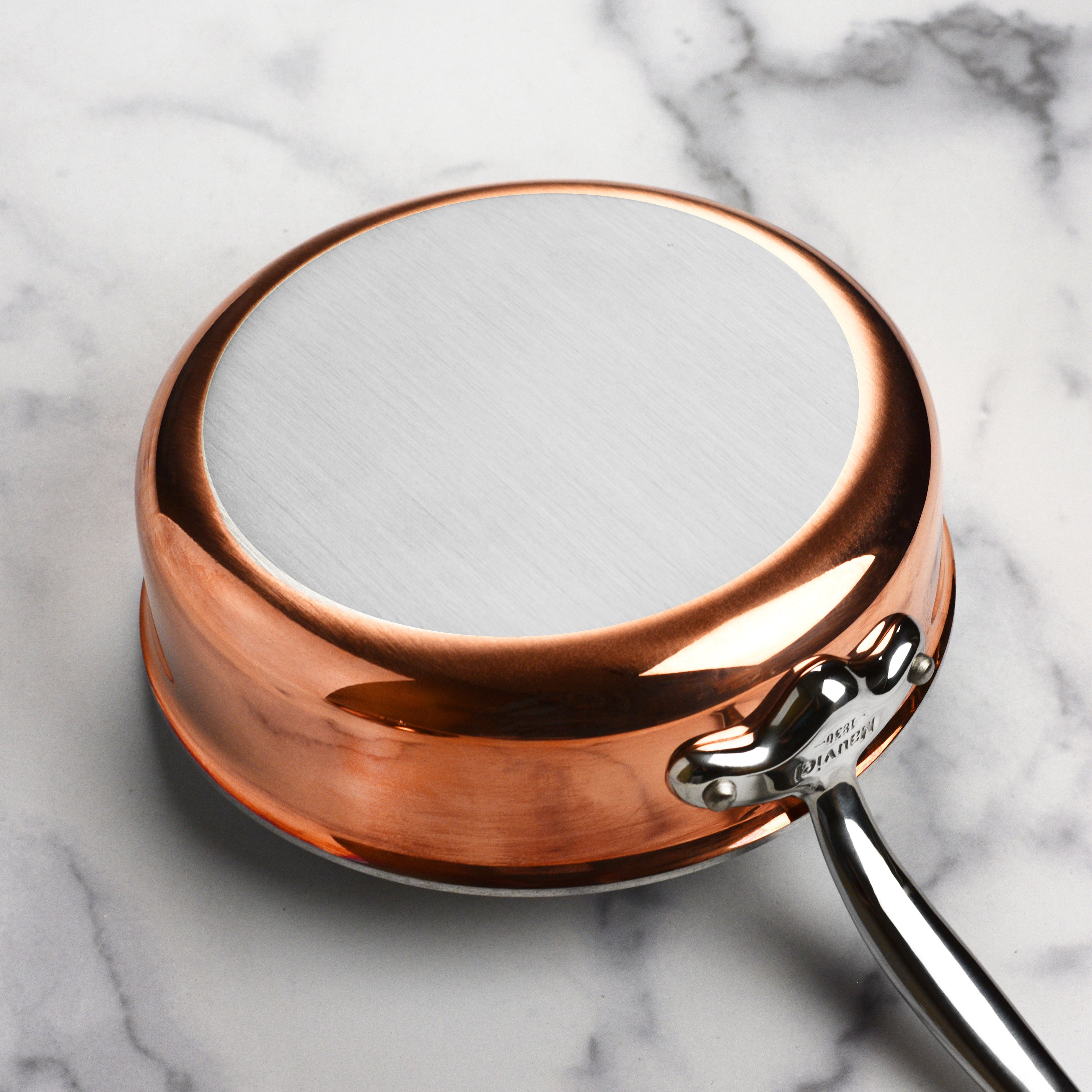 Mauviel M6S saute pan on an induction cooktop, showcasing its compatibility with various heat sources.