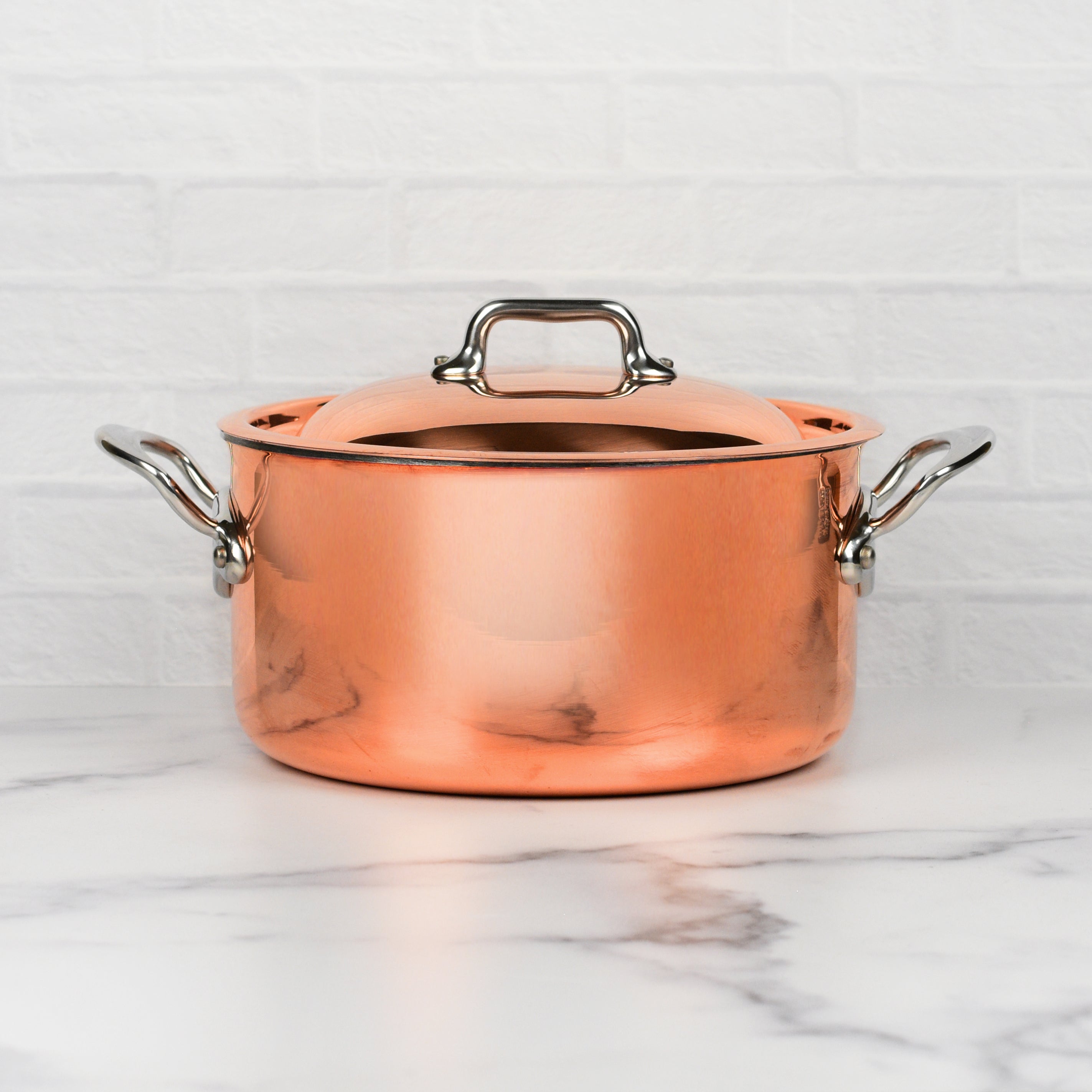 Mauviel M6S copper stock pot with lid displayed in a well-equipped kitchen.