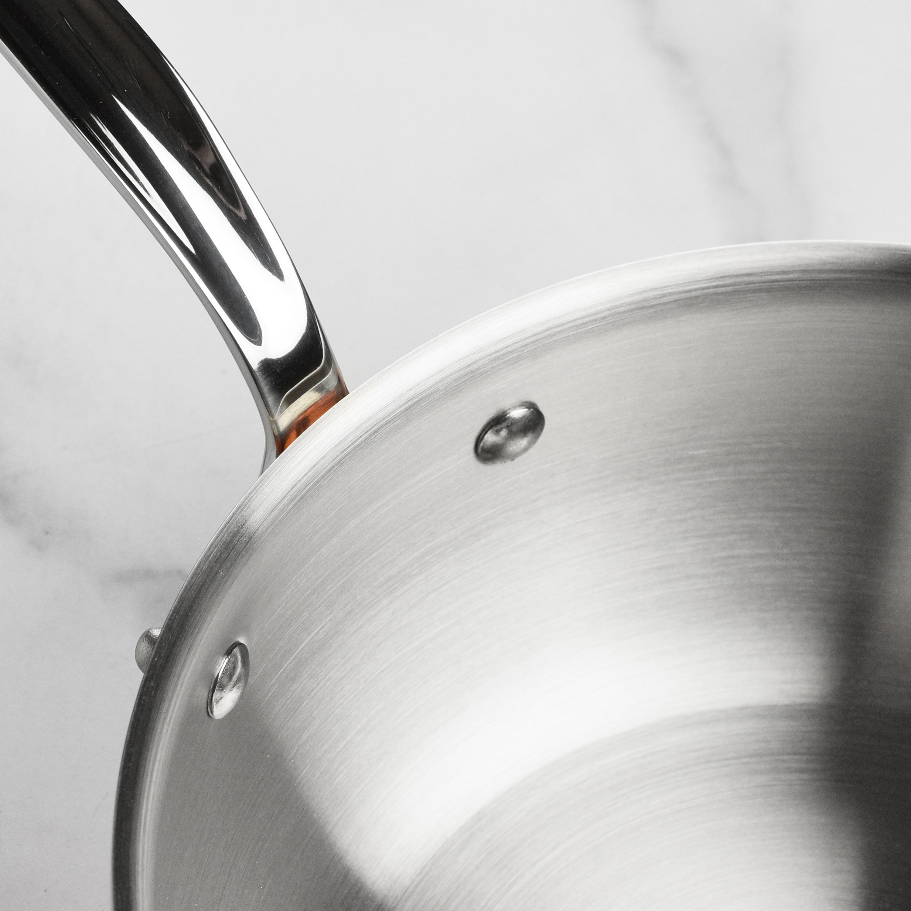 Angled overhead view of Mauviel M6S copper saucier showing flared rim and riveted stainless steel handle – ideal for induction cookware enthusiasts
