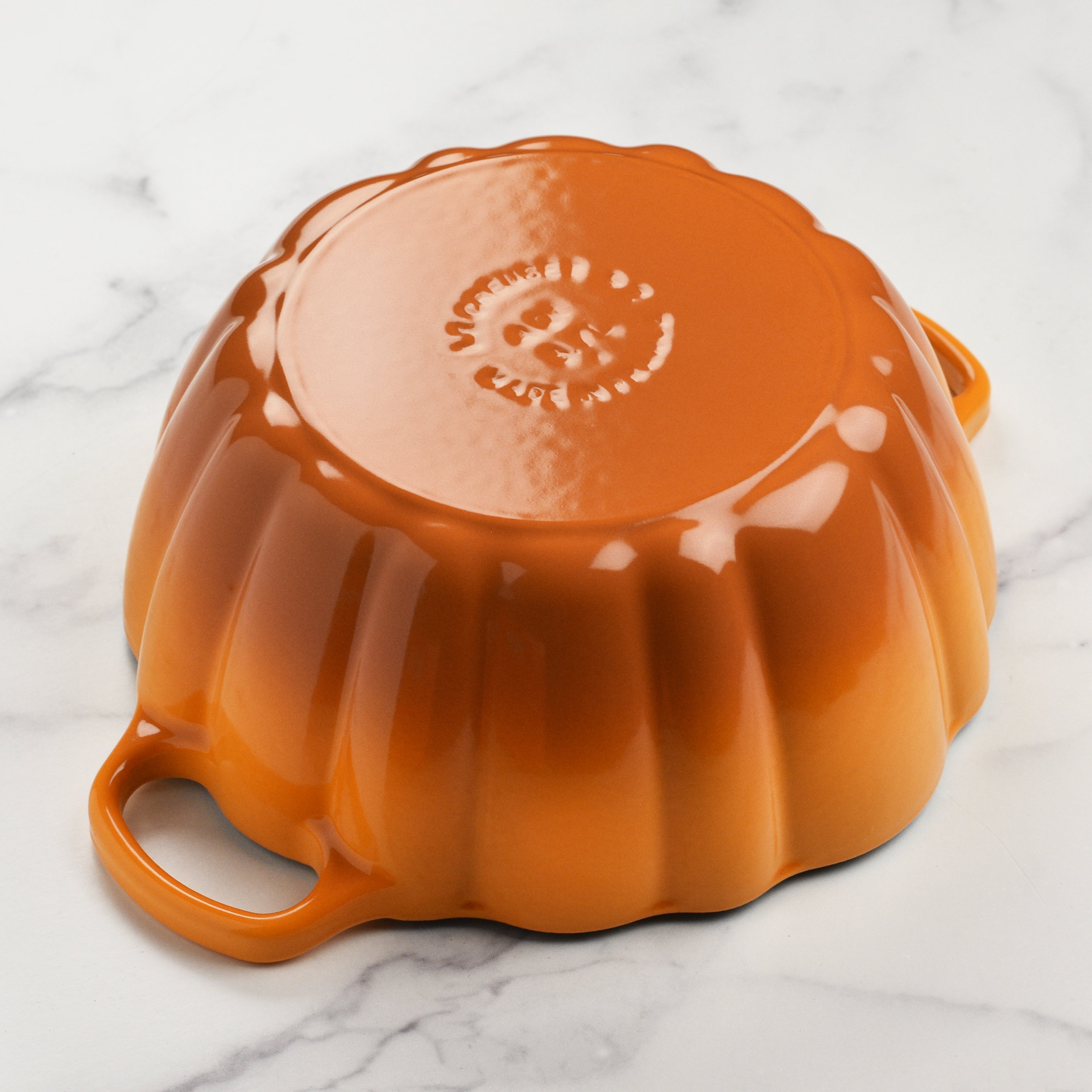 Close-up of the gold knob and ergonomic handles of the Le Creuset pumpkin cocotte.