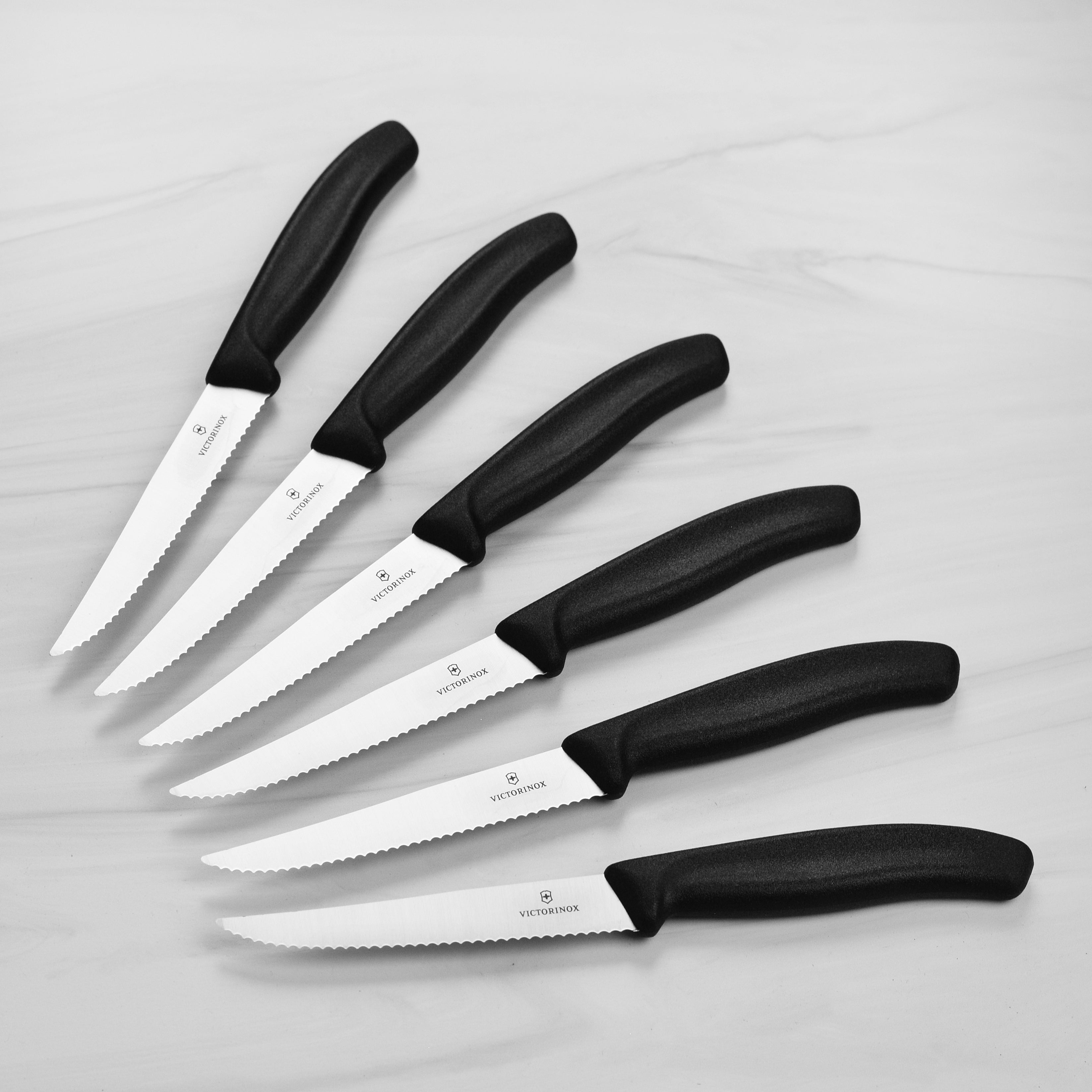 Close-up of the serrated blade edge from the Victorinox steak knife set, highlighting stainless steel finish.