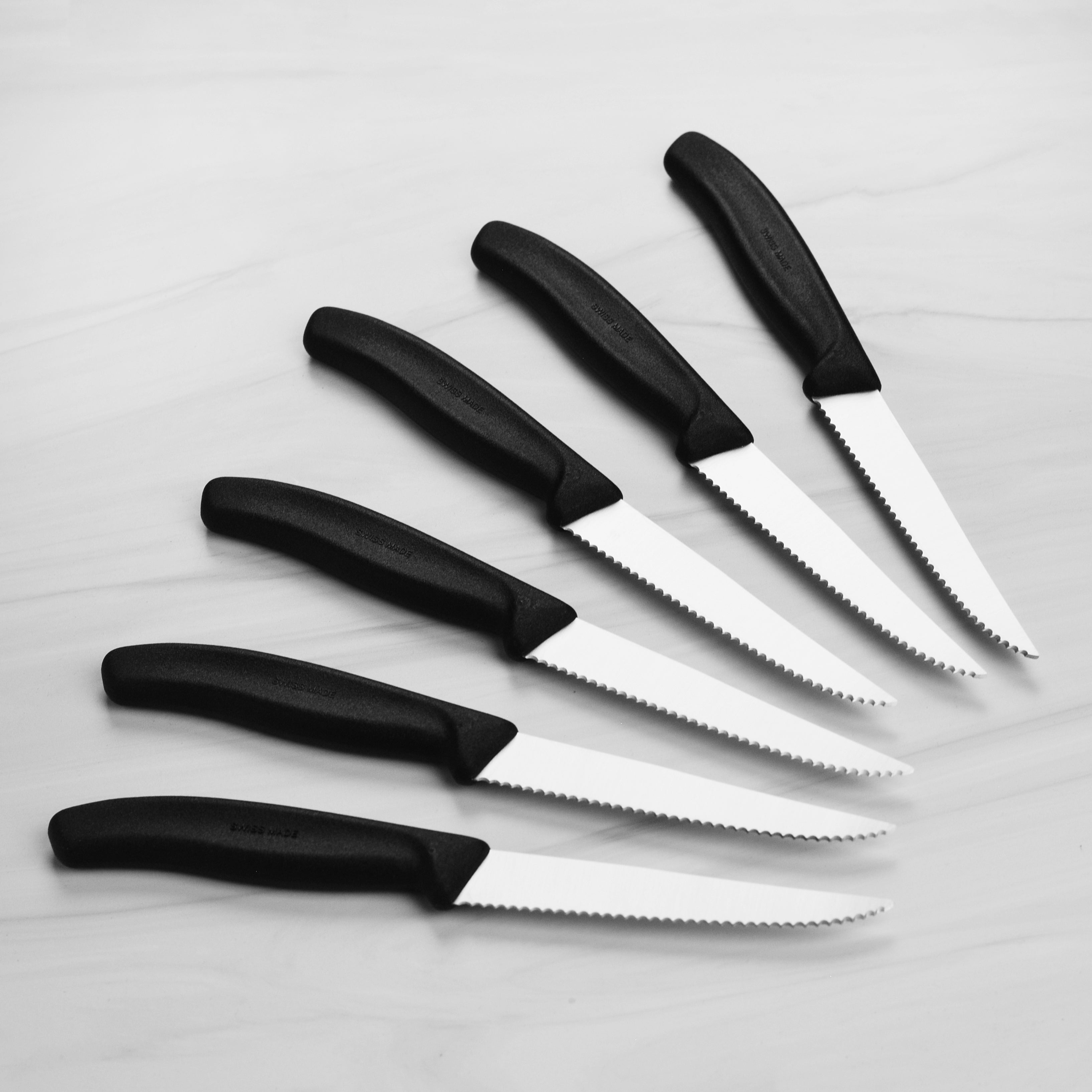 Close-up of the serrated blade edge from the Victorinox steak knife set, highlighting stainless steel finish.