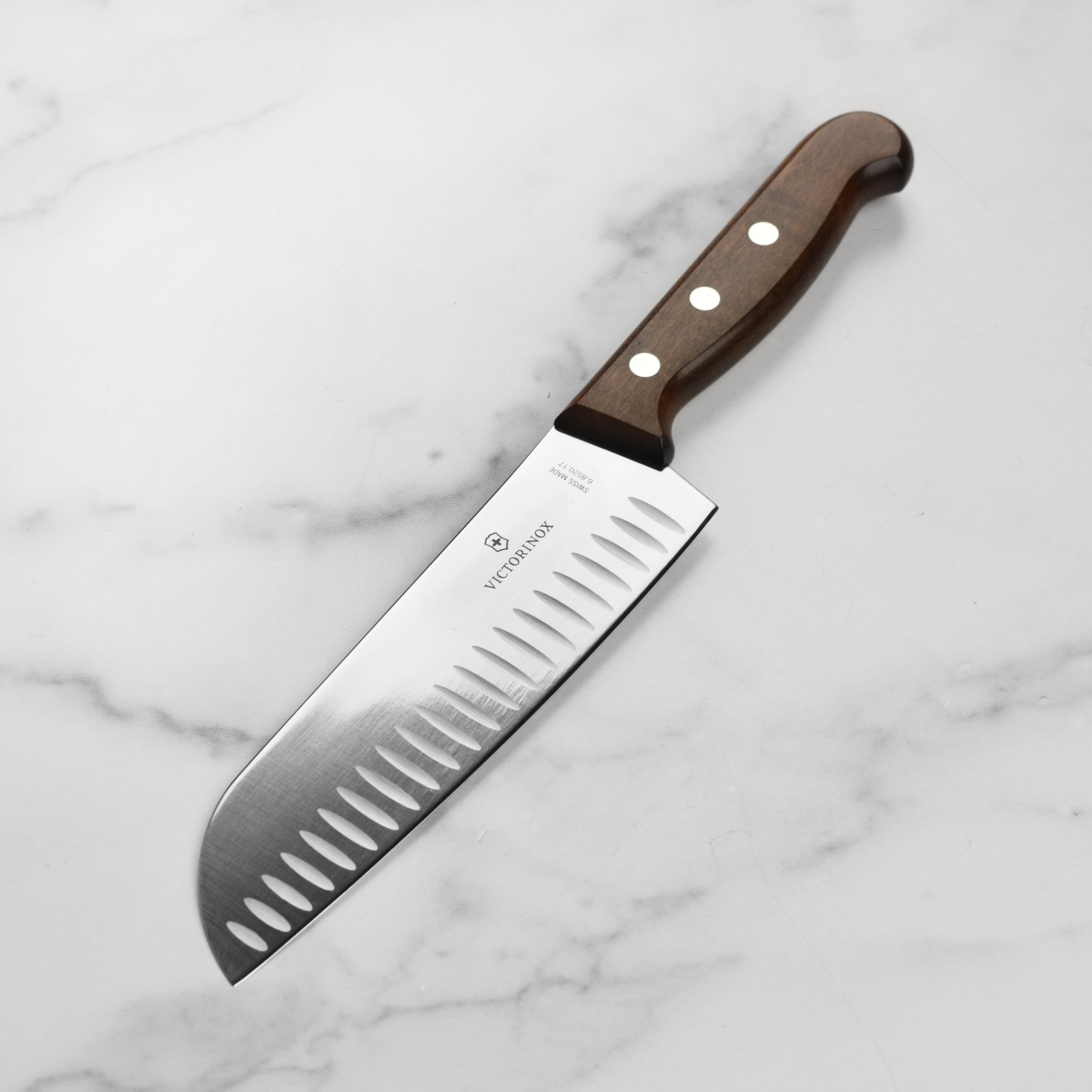 Victorinox 7-Inch Hollow Edge Santoku Knife with wood handle, angled view.