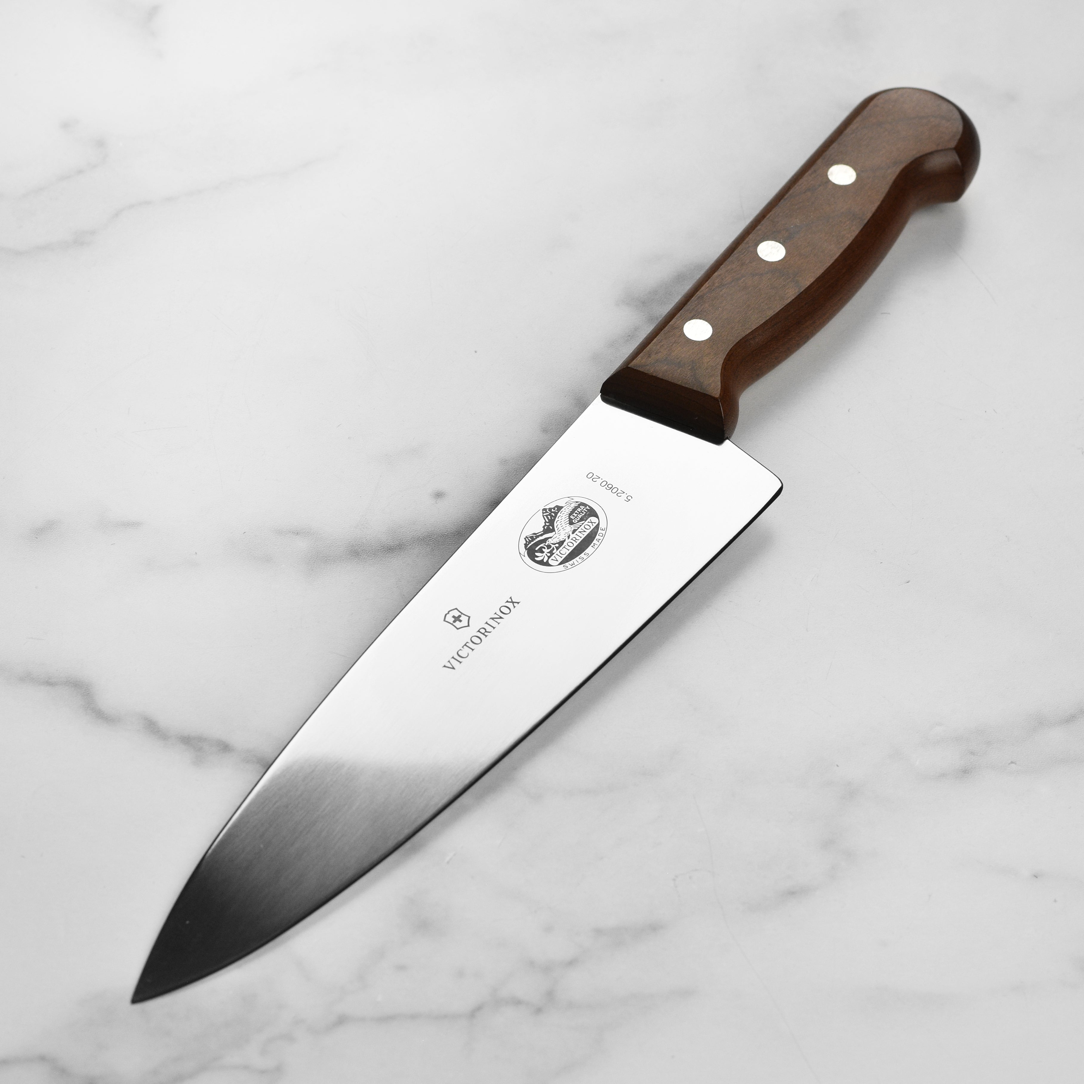 Victorinox 8-inch wooden handle chef's knife slicing vegetables in a modern kitchen