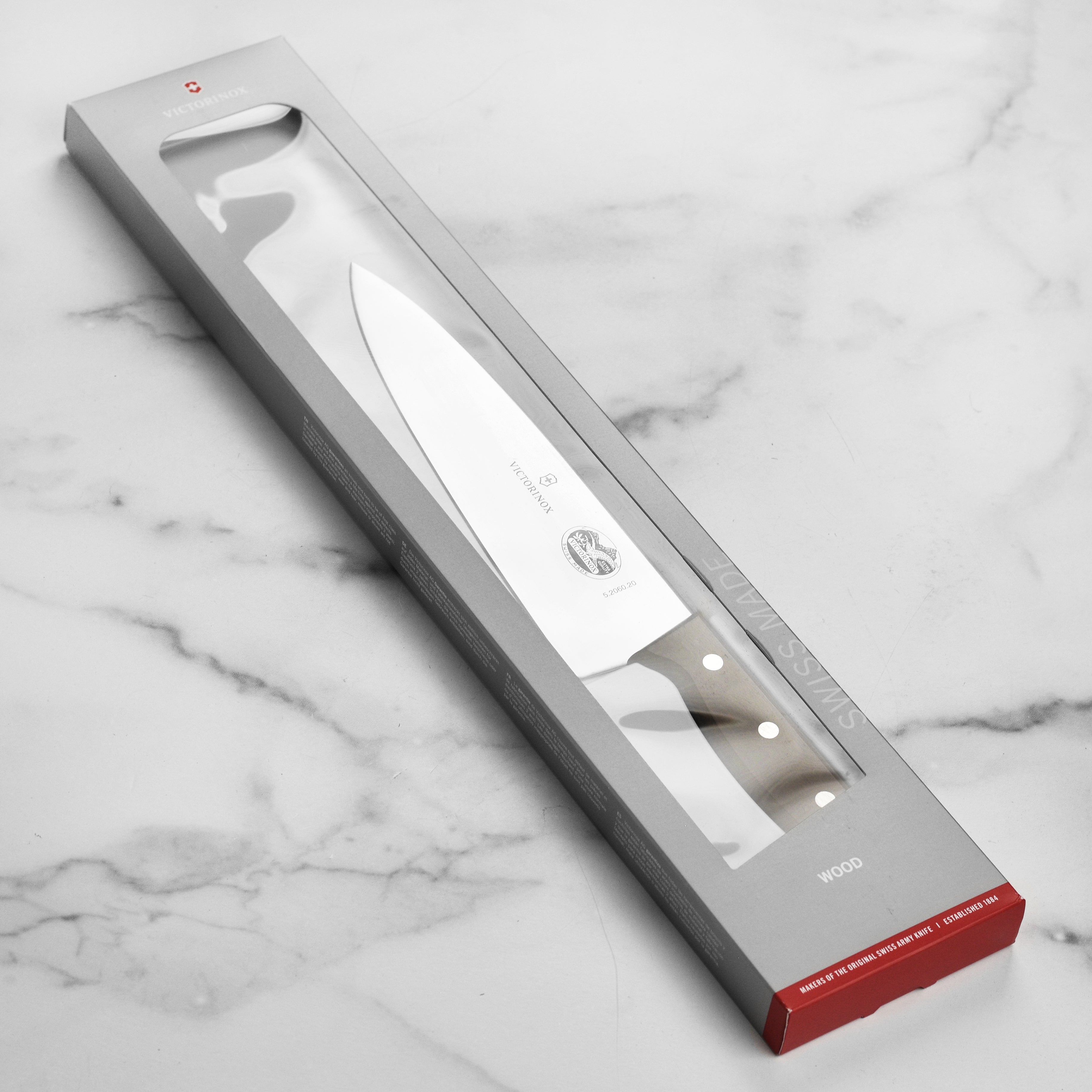 Victorinox 8-inch wooden handle chefs knife slicing vegetables in a modern kitchen