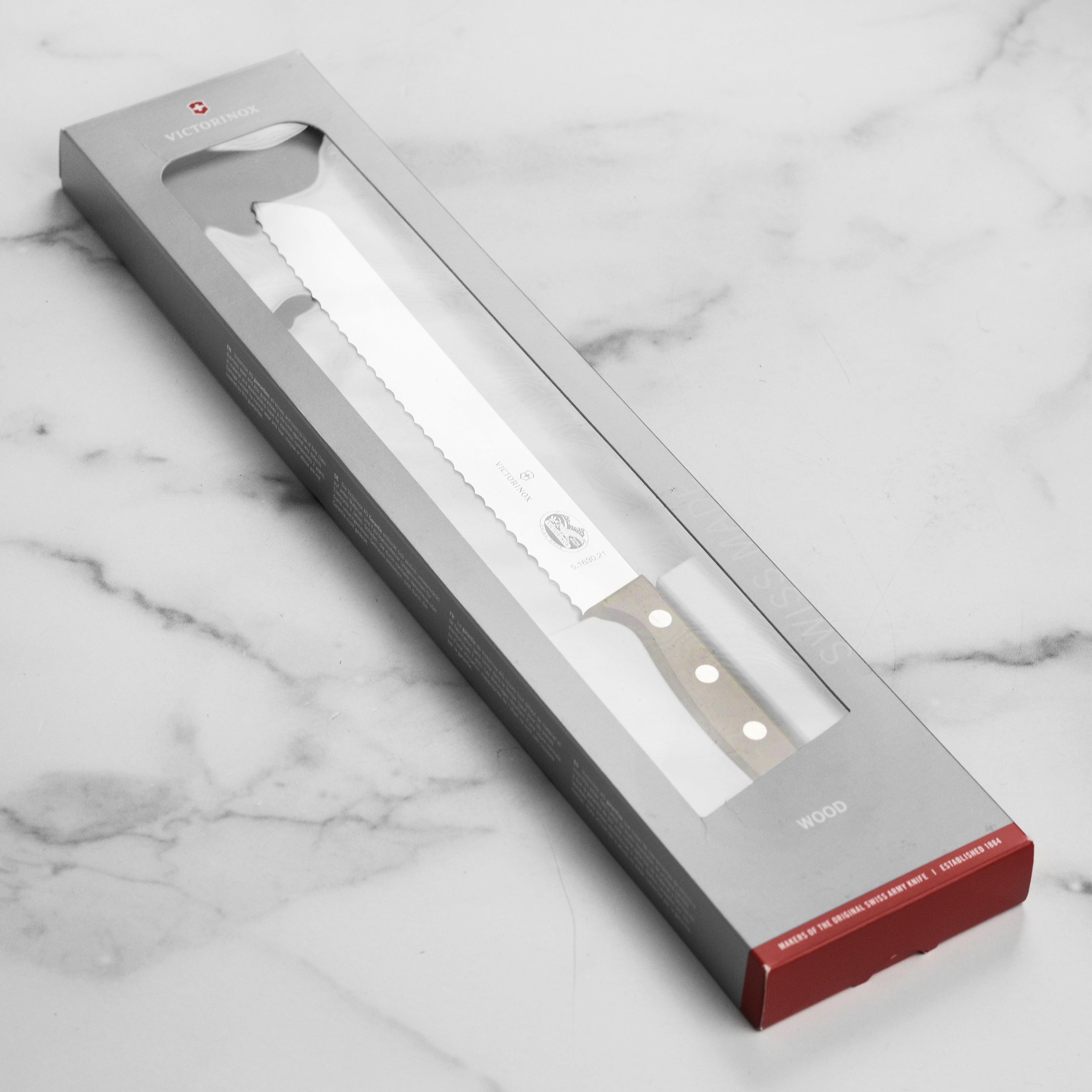 Victorinox bread knife with wooden handle slicing crusty bread on a cutting board
