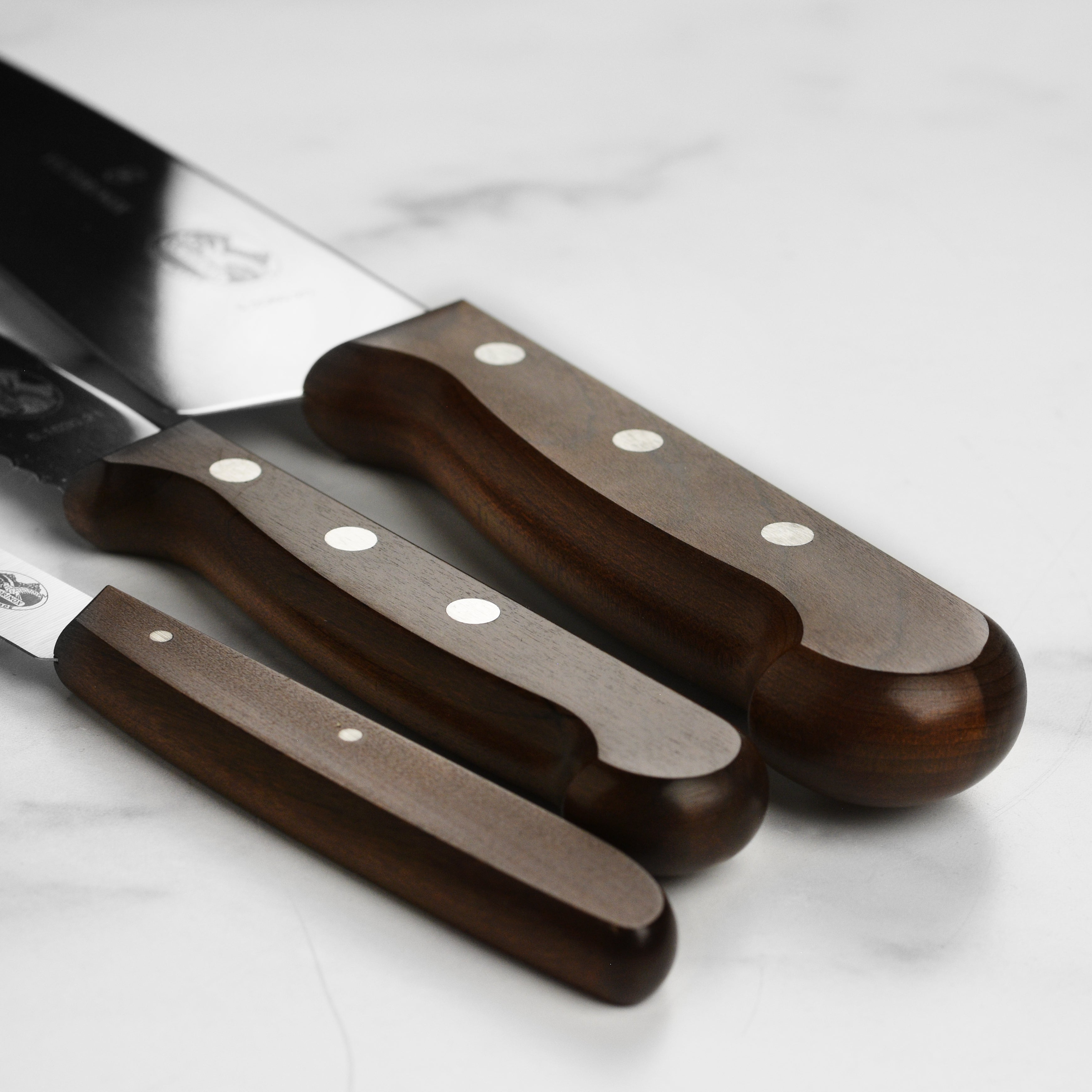 Chef using the Swiss Precision Wood Knife Set for slicing vegetables in a modern kitchen.
