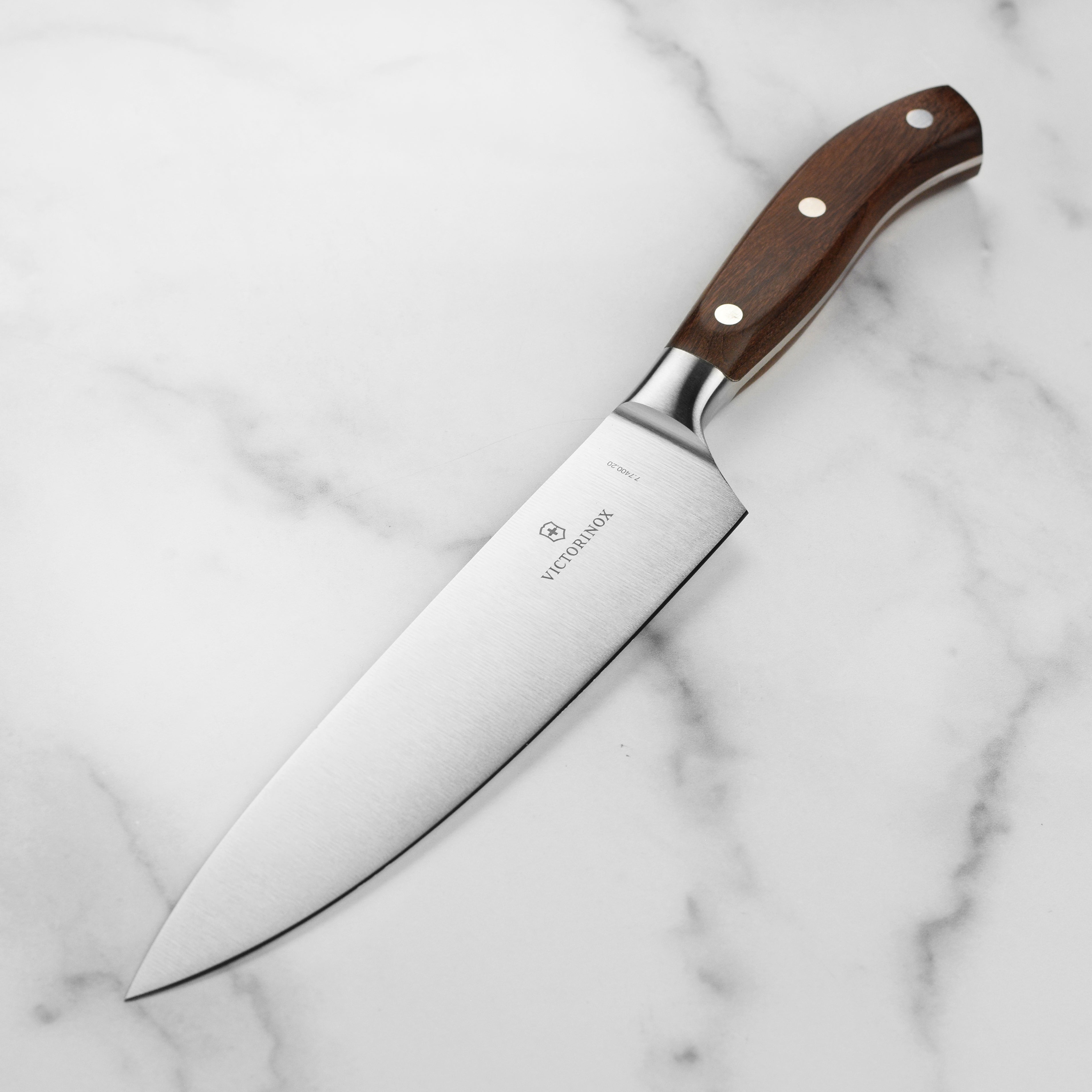 Victorinox Grand Maitre Wood 8-inch chef's knife with wooden handle on a cutting board