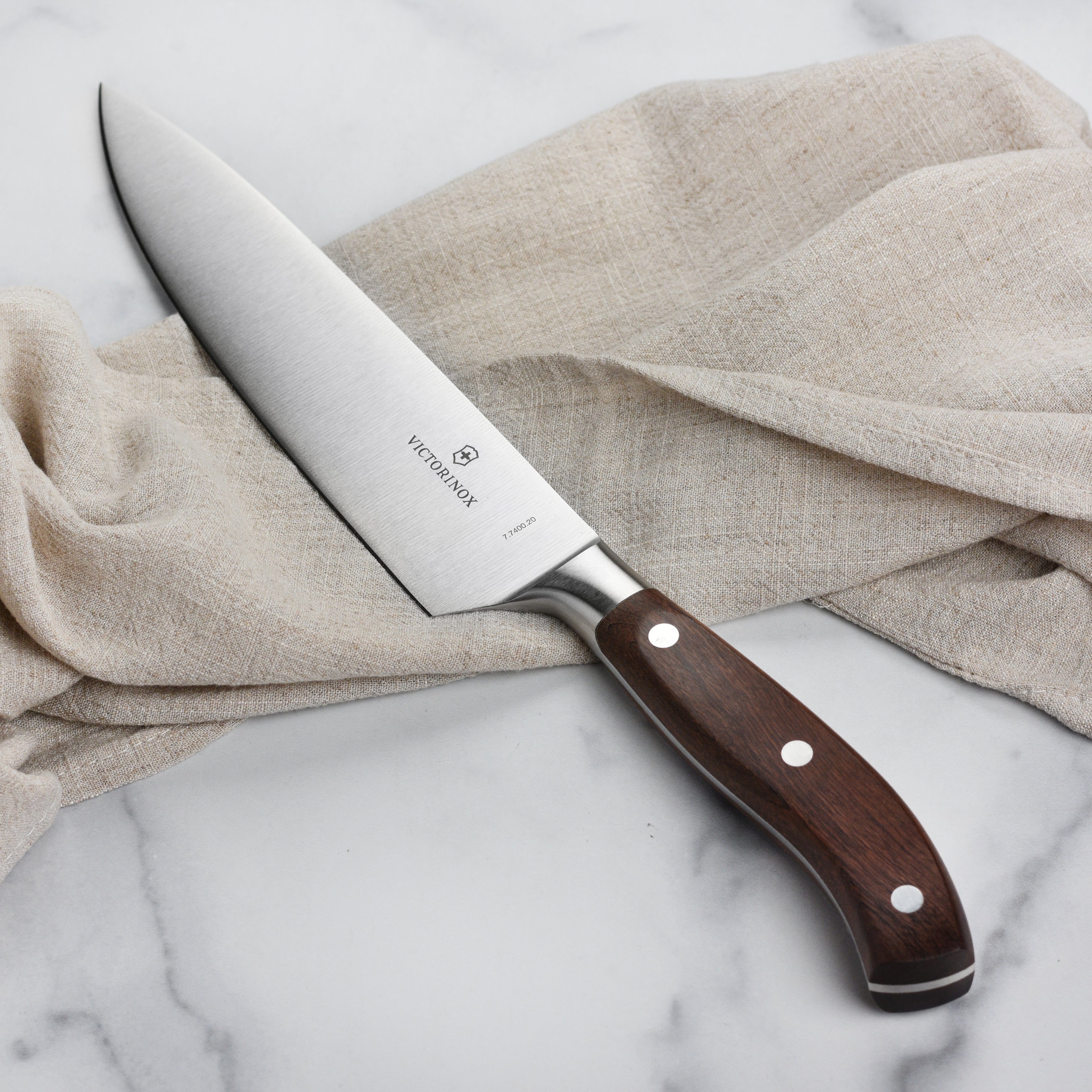 Victorinox Grand Maitre Wood 8-inch chefs knife with wooden handle on a cutting board