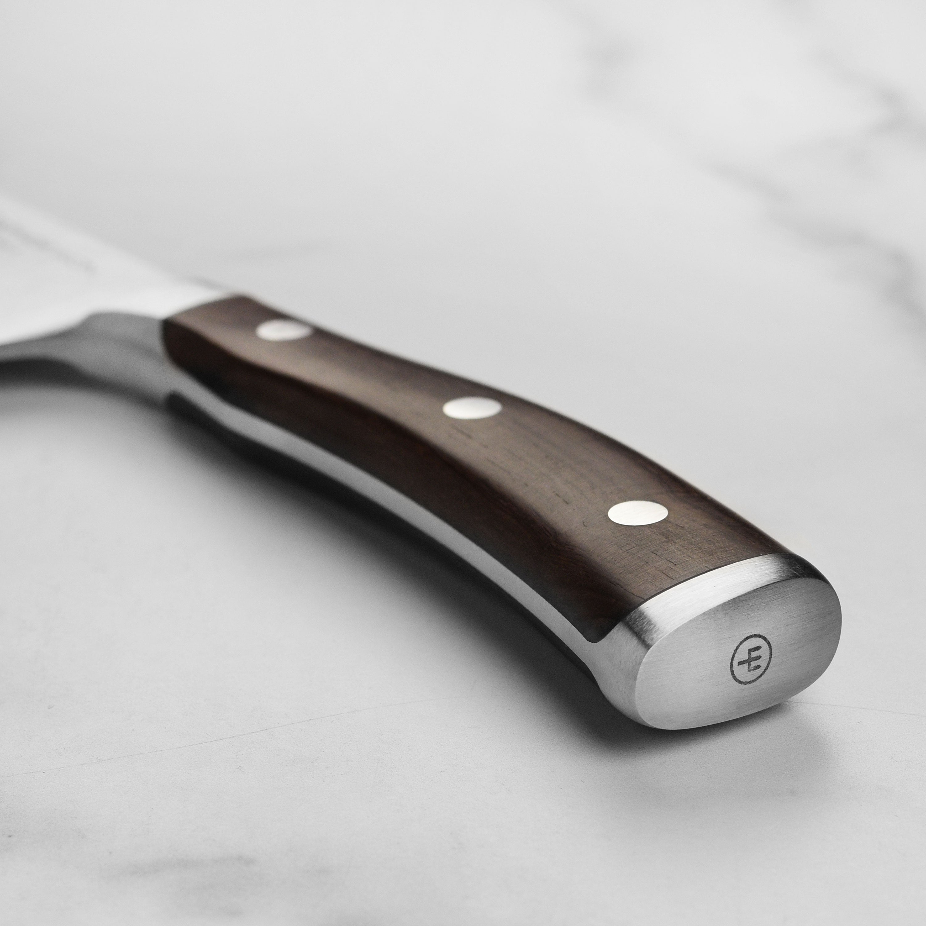 Close-up of the Grenadill wood handle of the Wusthof Ikon Chinese chef knife, highlighting its craftsmanship and comfort.