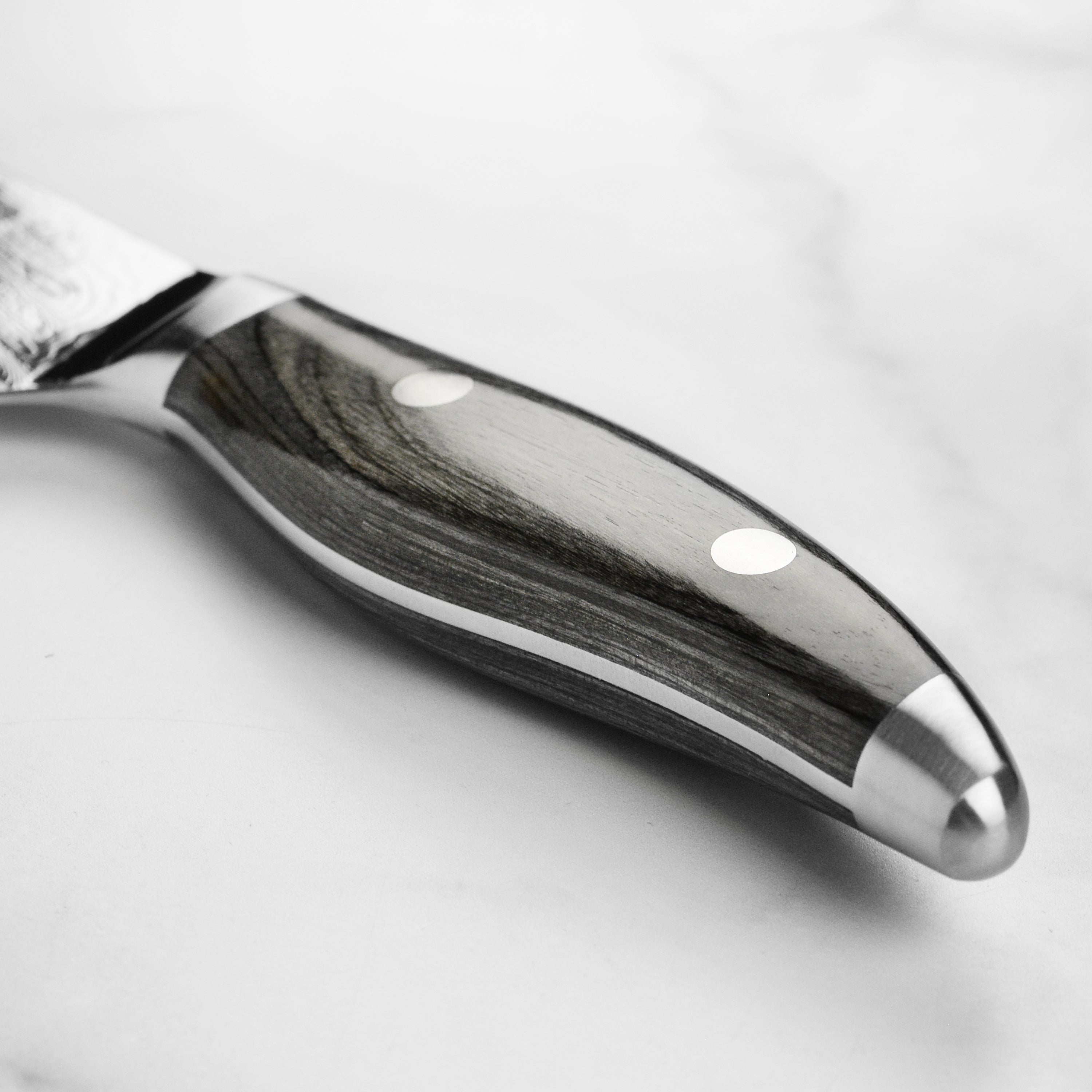 Close-up of the Shun Nagare knifes pakkawood handle, highlighting its double-riveted design for better grip.