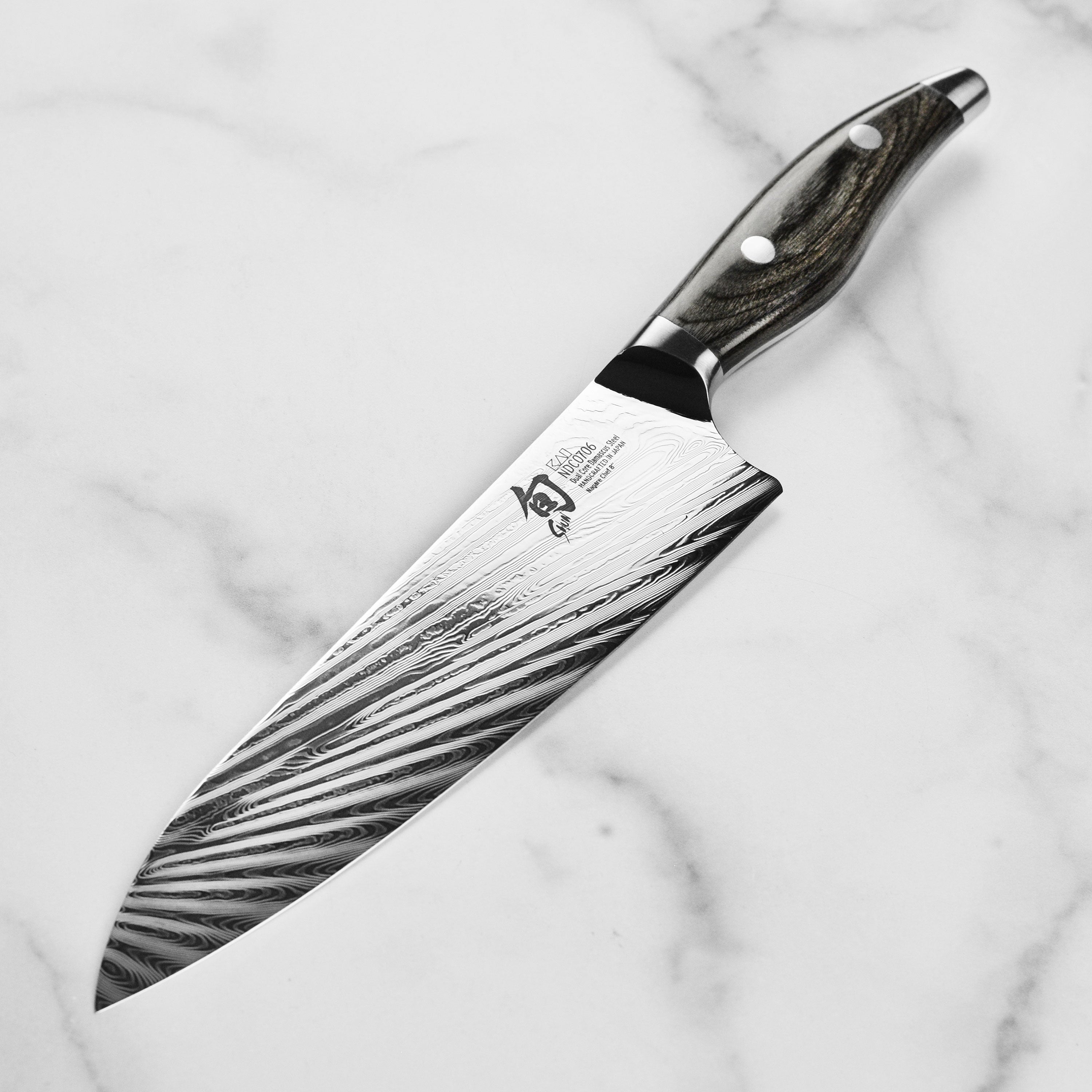 Chef using the Damascus knives for preparing gourmet dishes in a modern kitchen setting.