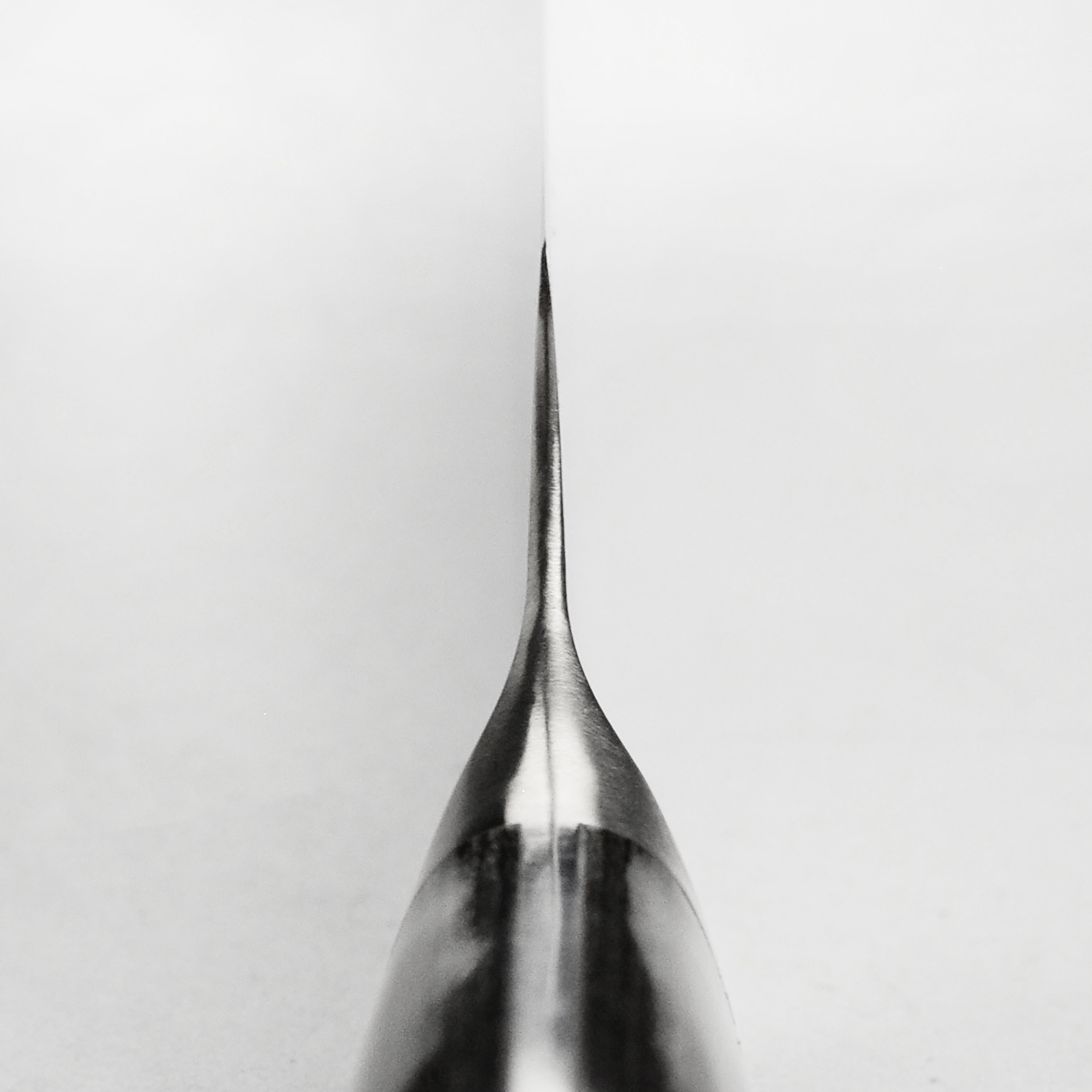 Side view of the Shun Nagare 6-Inch Utility Knife revealing the intricate Damascus pattern and sharp edge.