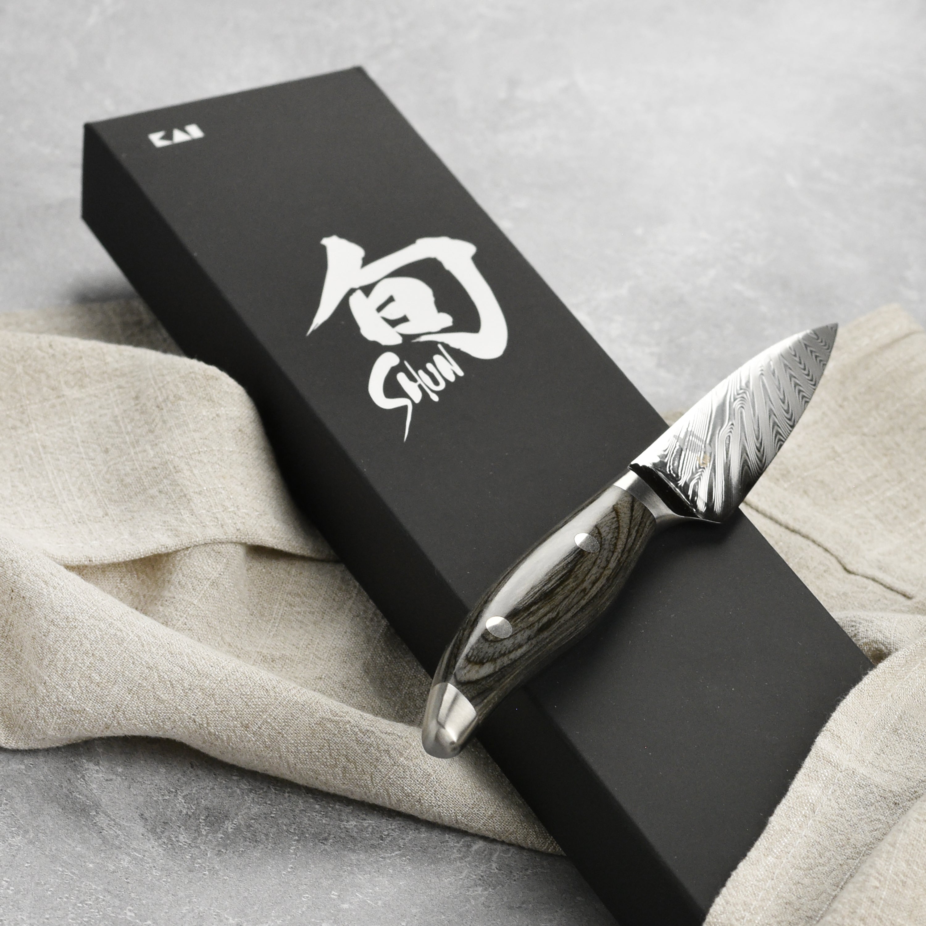 Ergonomic pakkawood handle on the Shun Nagare paring knife, designed for comfort during intricate prep work