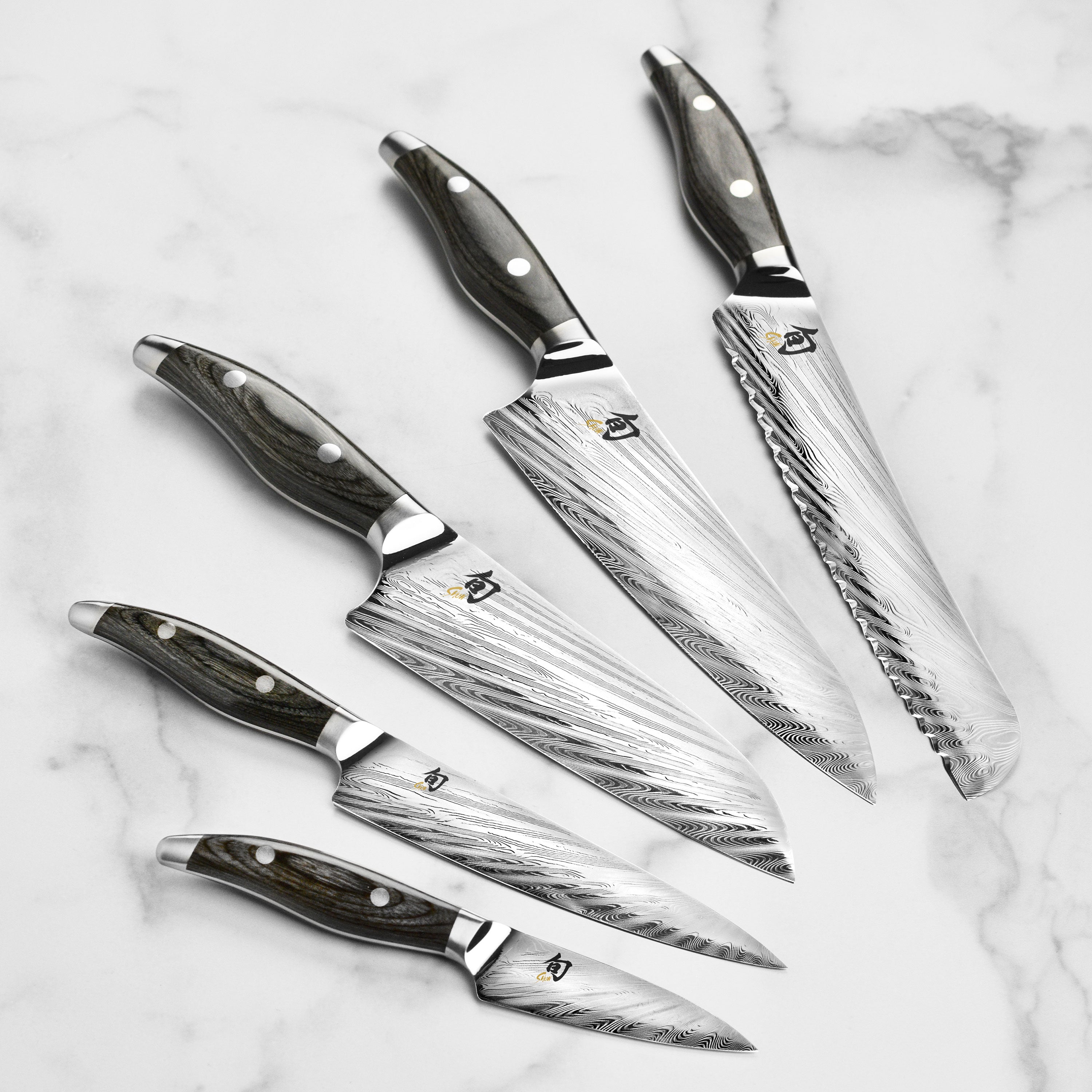 Chef using the Damascus knives for preparing gourmet dishes in a modern kitchen setting.