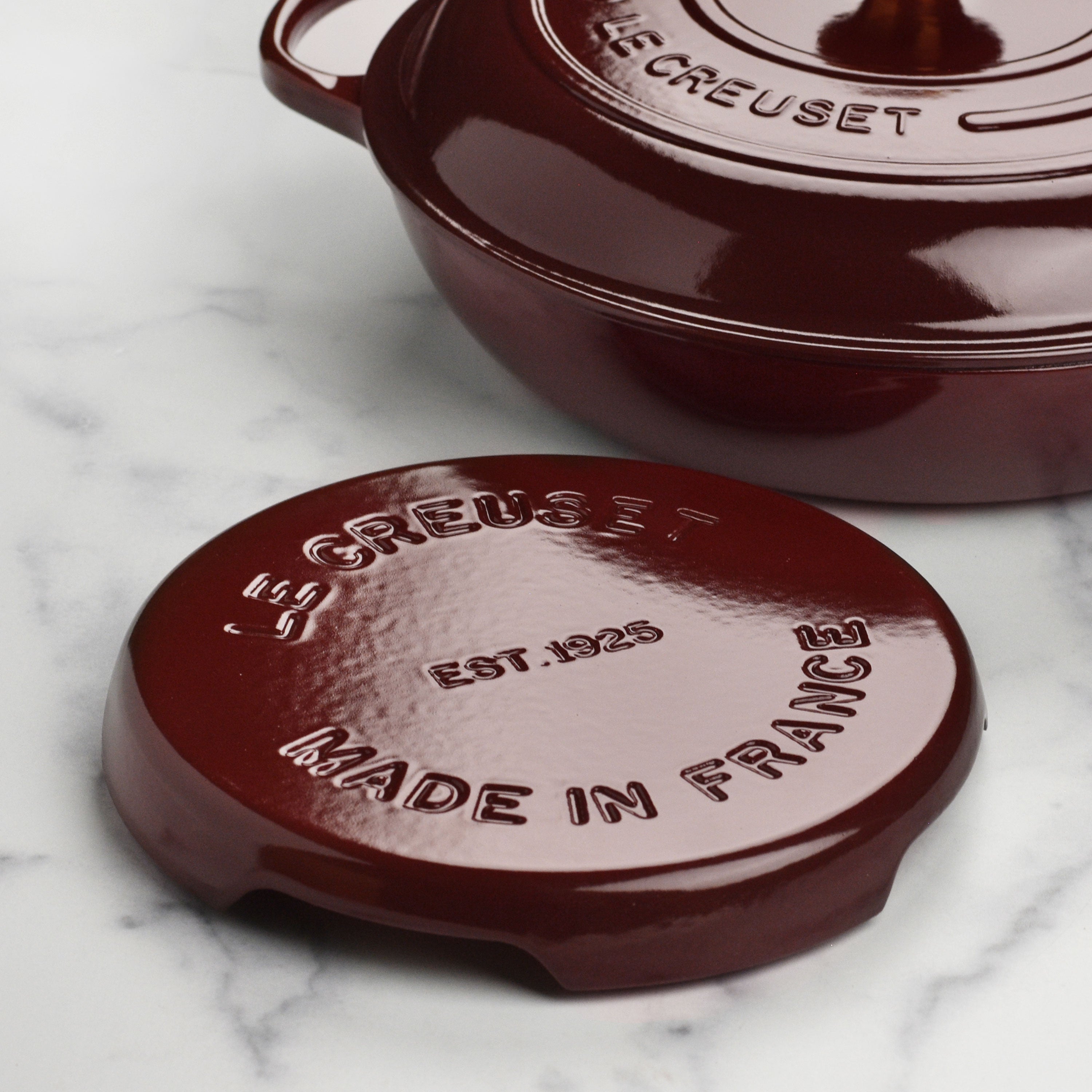 Close-up of the Le Creuset cast iron trivet in Rhone red on a kitchen countertop