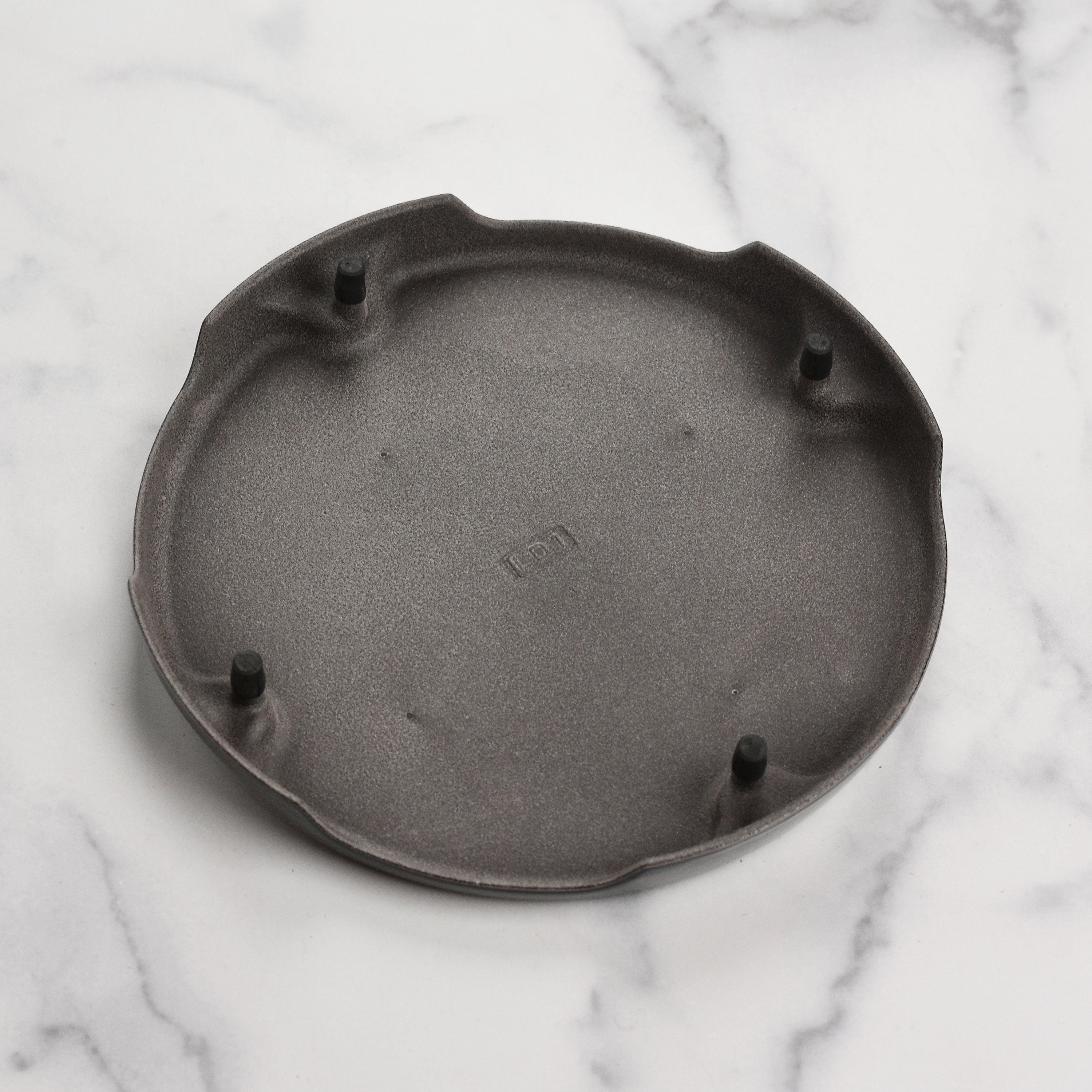 Le Creuset cast iron trivet in oyster color, perfect for hot dishes.