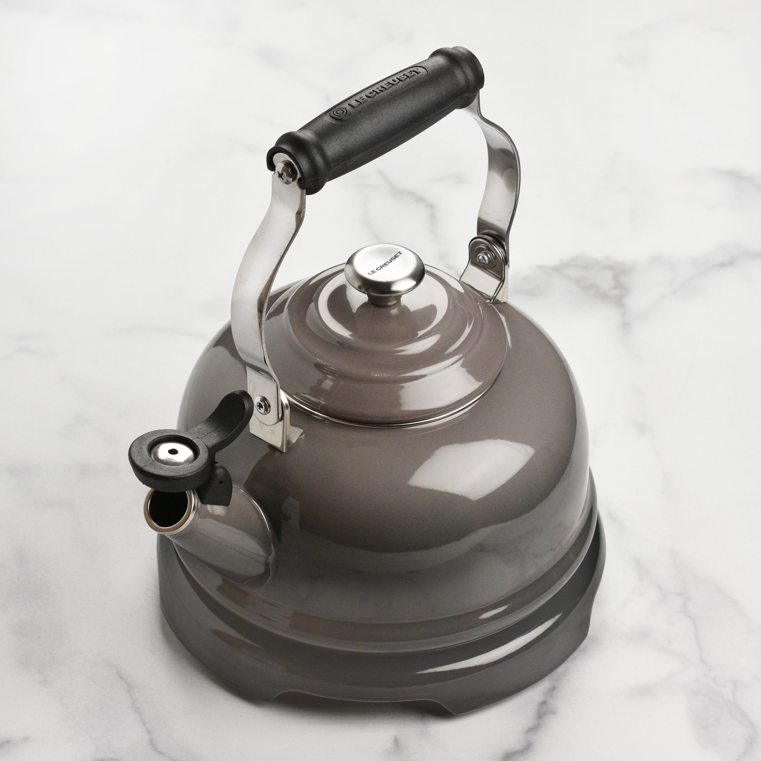 Elevated design of Le Creuset trivet protecting a wooden table from heat.