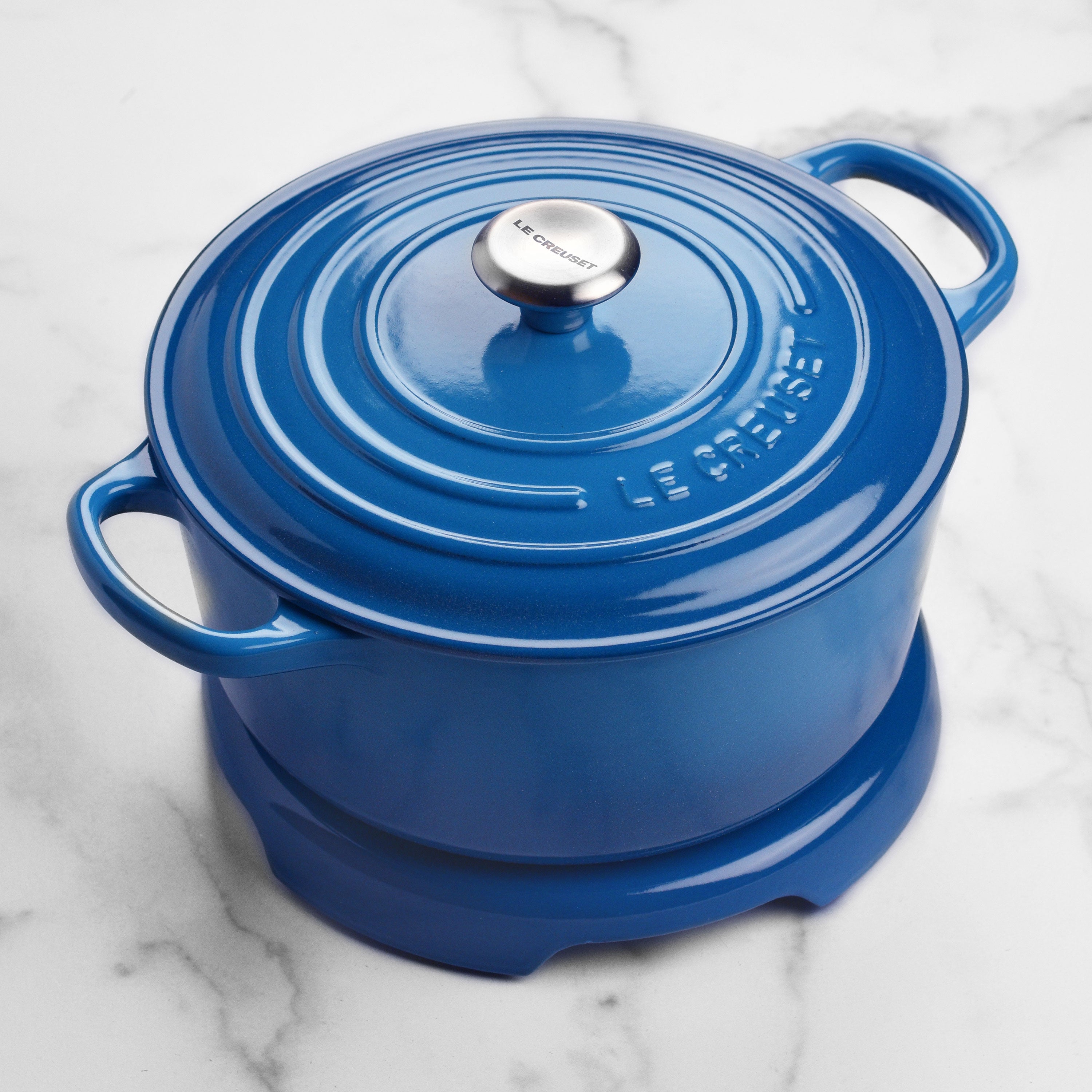 Le Creuset trivet in use, protecting a wooden table from a hot pot.